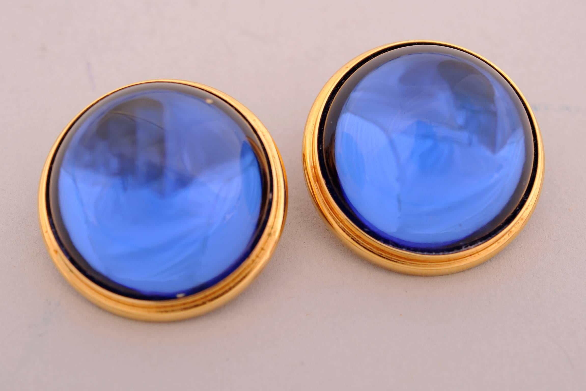 Lalique  blue crystal cabochons are ringed with a raised gold toned band. The earrings are clip backs and are marked Lalique, France on the back. They are in excellent condition.
Measurements;
Height 1/2