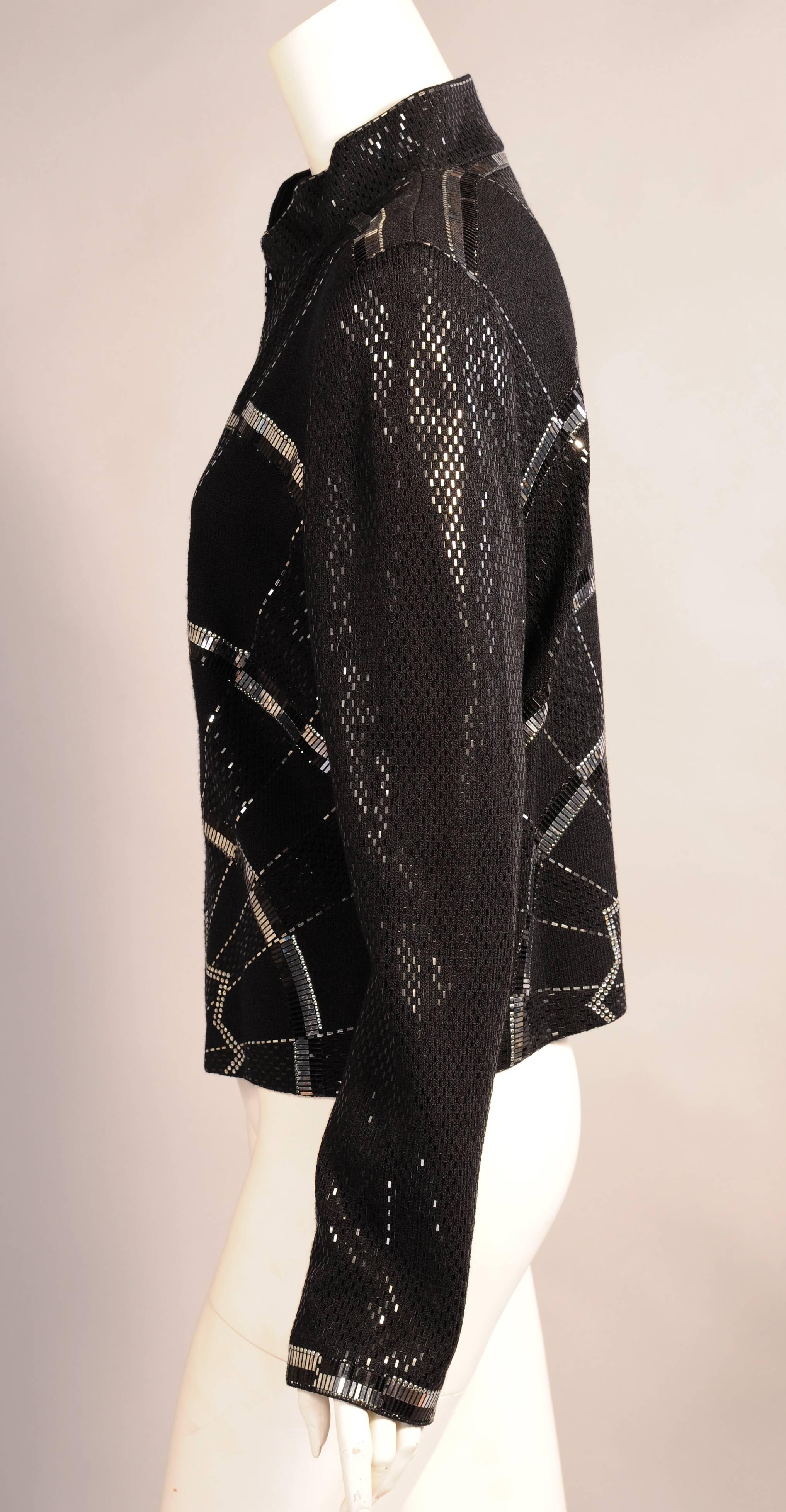 An Art Deco inspired bold and graphic design is worked in silver and black on this chic black wool jacket. Long flat black and silver bands, small silver dots, rhinestones and black sequins are all used in the design. The jacket has a zippered