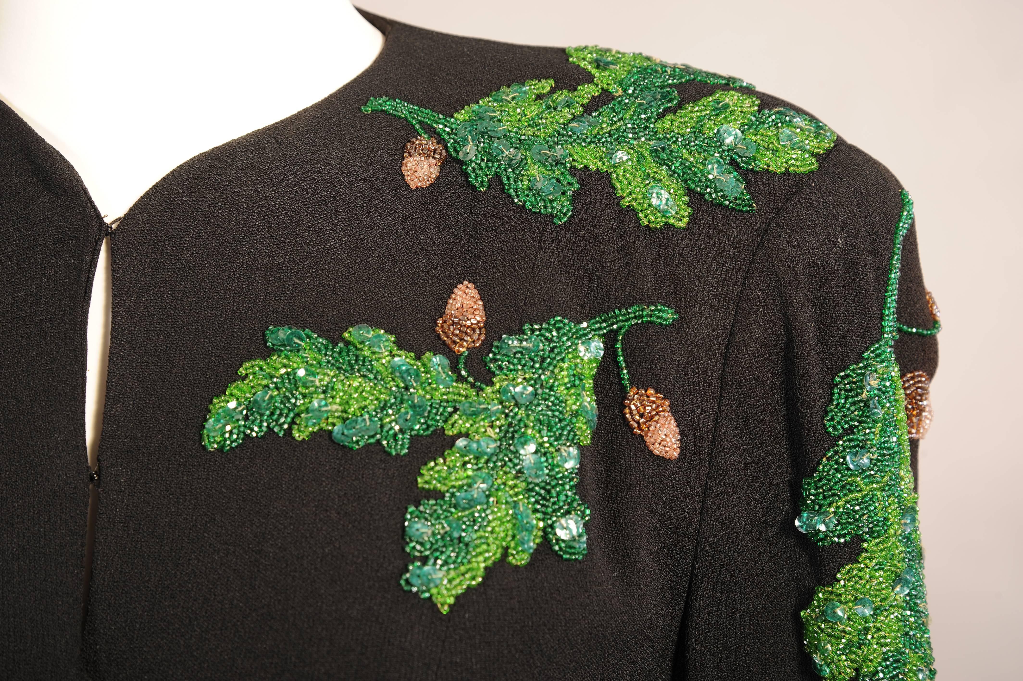 This clean lined 1940's black crepe jacket has a five button closure, two faux pockets and fantastic beaded decoration.  The oak leaves are done with caviar beads in several shades of green which are enhanced with green sequins for added depth of