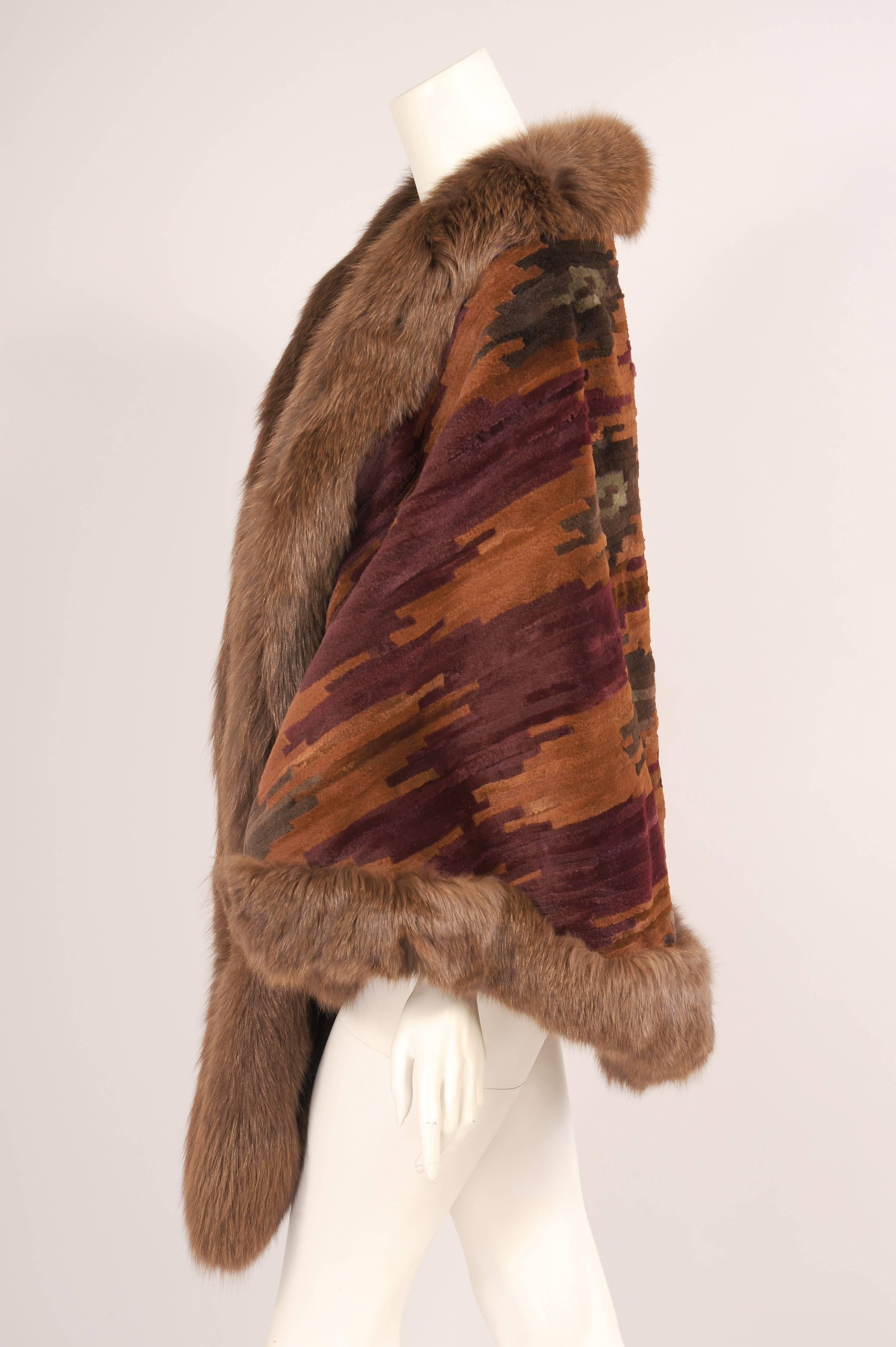 Sheared mink is dyed burgundy, camel and olive green in a graphic pattern for this fabulous wrap designed by the late Oscar de la Renta. The generously sized fur wrap is edged with a luxurious fox fur trim on all three sides. It is fully lied with