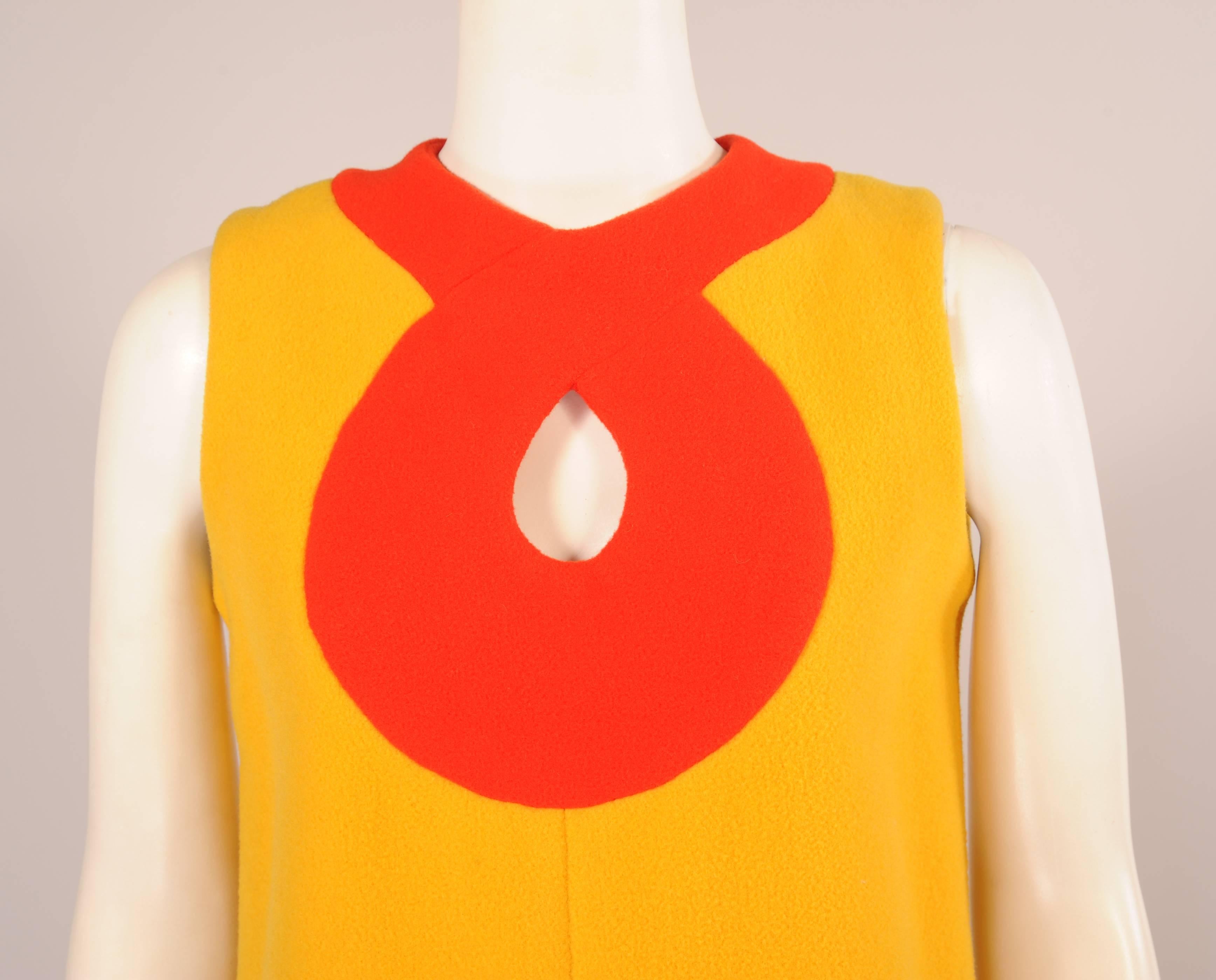 A cheerful combination of bright yellow and red wool makes this a very eye catching 1960's A-line dress. A wide band of red wool encircles the neckline and creates a keyhole neckline which matches the wide band at the hemline. The dress has a cnter
