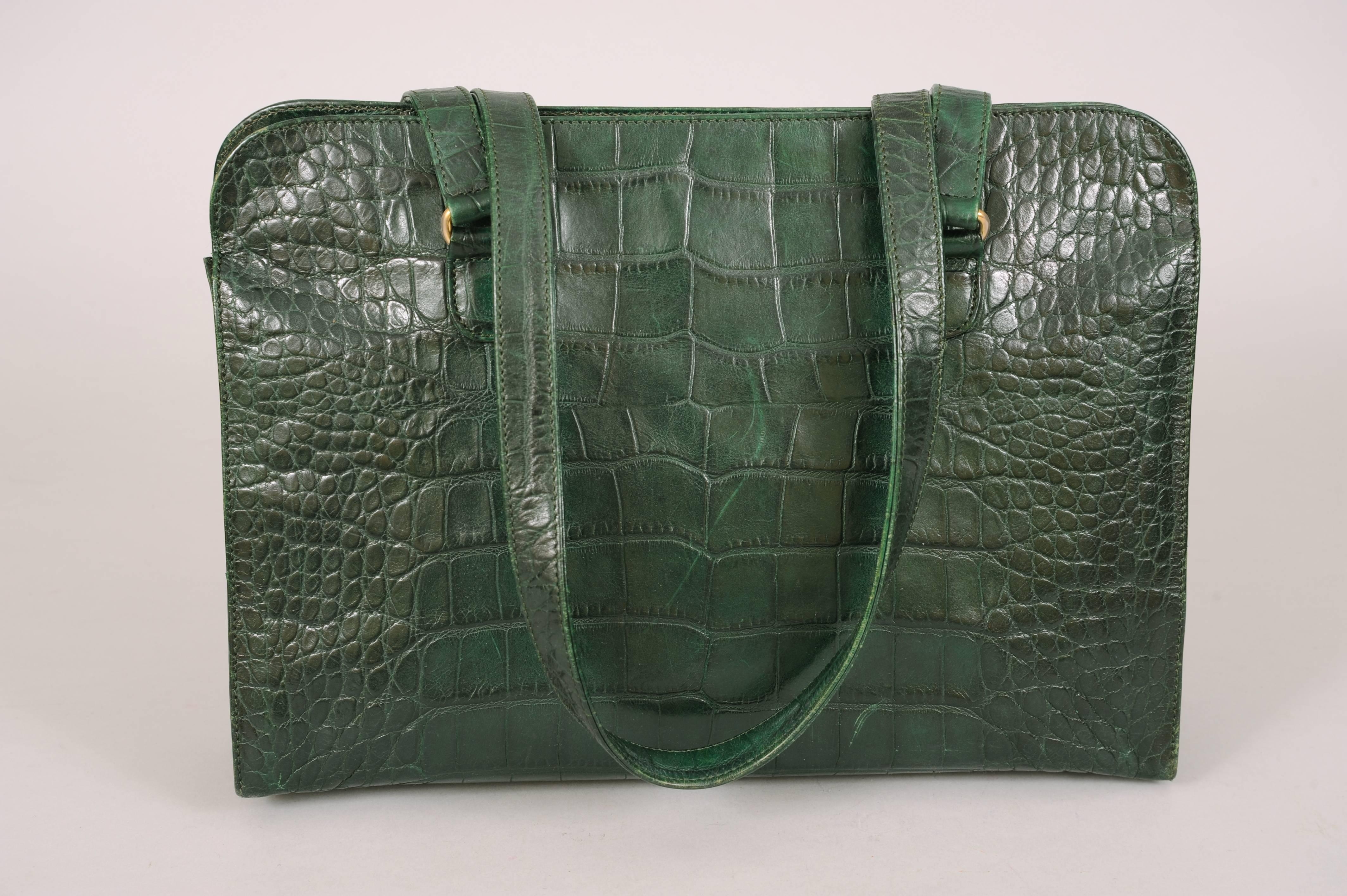A beautiful deep green leather is patterned to resemble alligator skin for this zip top shoulder bag designed by Sonia Rykiel. Lined in pristine black logo fabric the bag has an interior zipper pocket. The straps can be worn on the shoulder or used