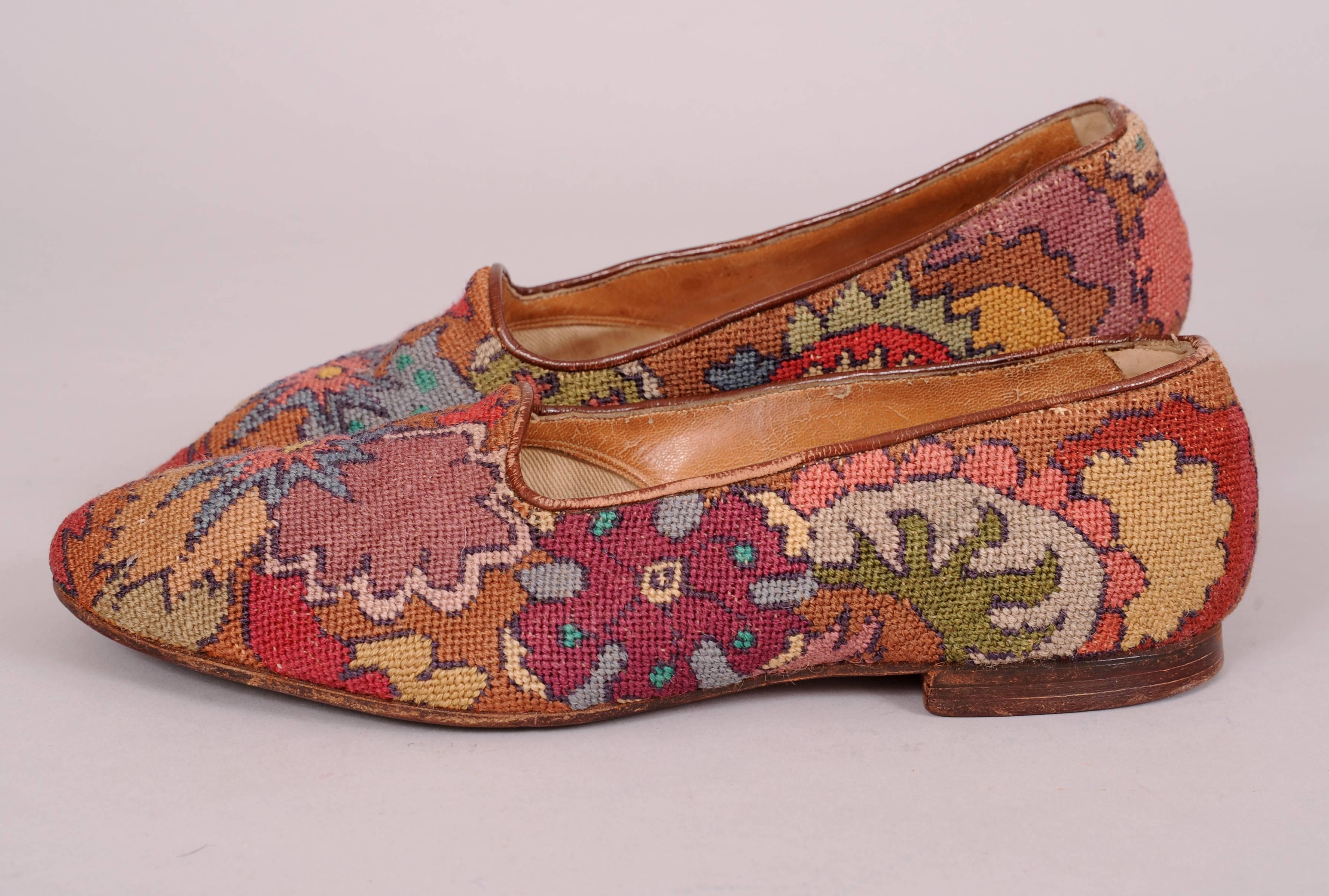 A fabulous design in a multitude of colors makes these leather and hand done needlepoint slippers a standout. Hand stitched in shades of blue, brown, green, red, grey camel and rose they are just so chic. The interior label is illegible and they are