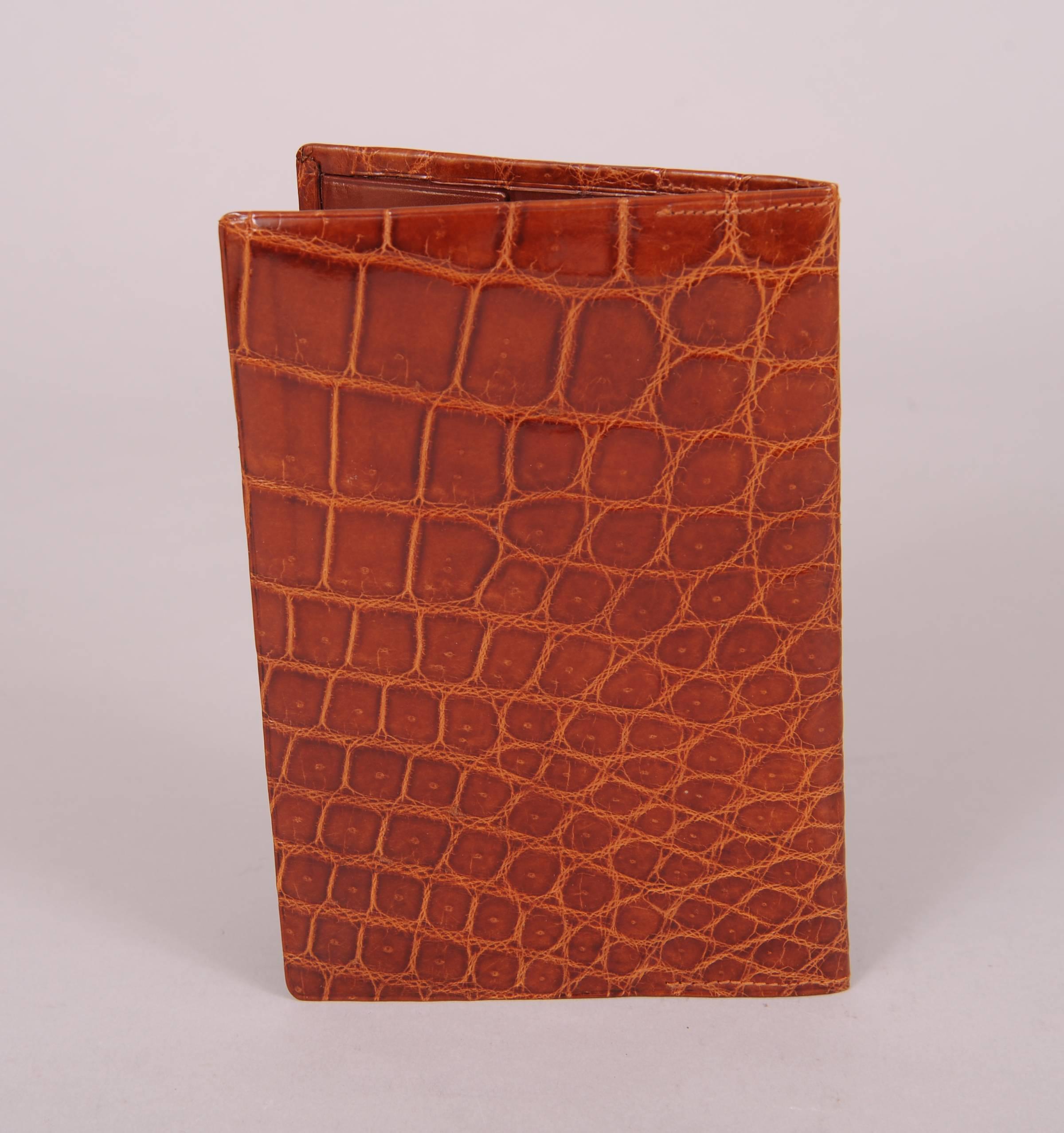 Supple brown crocodile covers the outside of this pristine vintage wallet. The butter soft brown leather interior is a perfect complement to the skin. There are seven sections inside for all of your cash, cards and receipts.  It was never used and