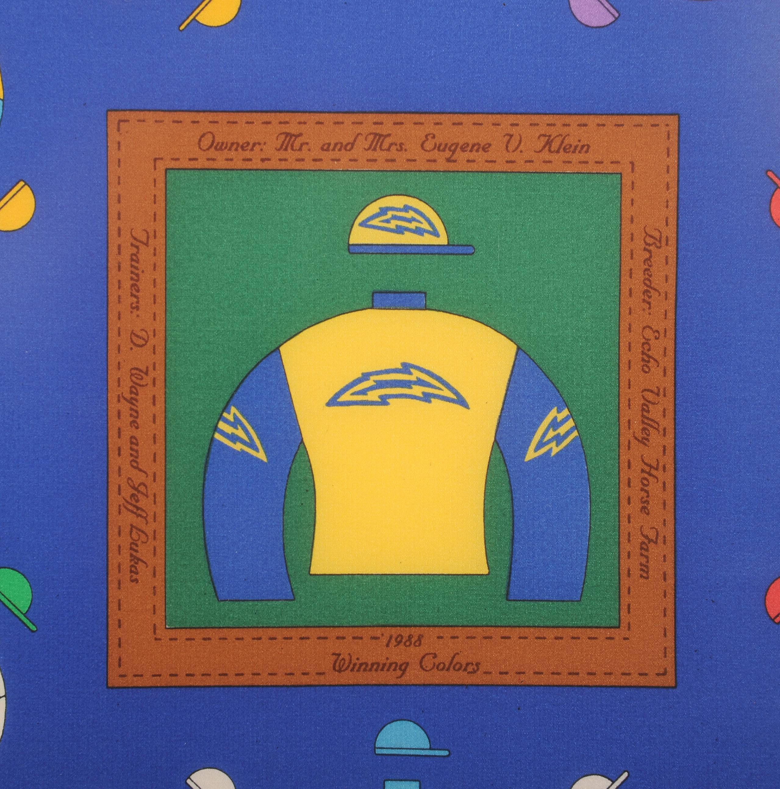 The center square depicts colorful racing silks of the 1988 Derby Winner Winning Colors. This is surrounded by jockey silks from all of the winners from 1875 until 1987 set against a blue background and the green border.  The four corners depict