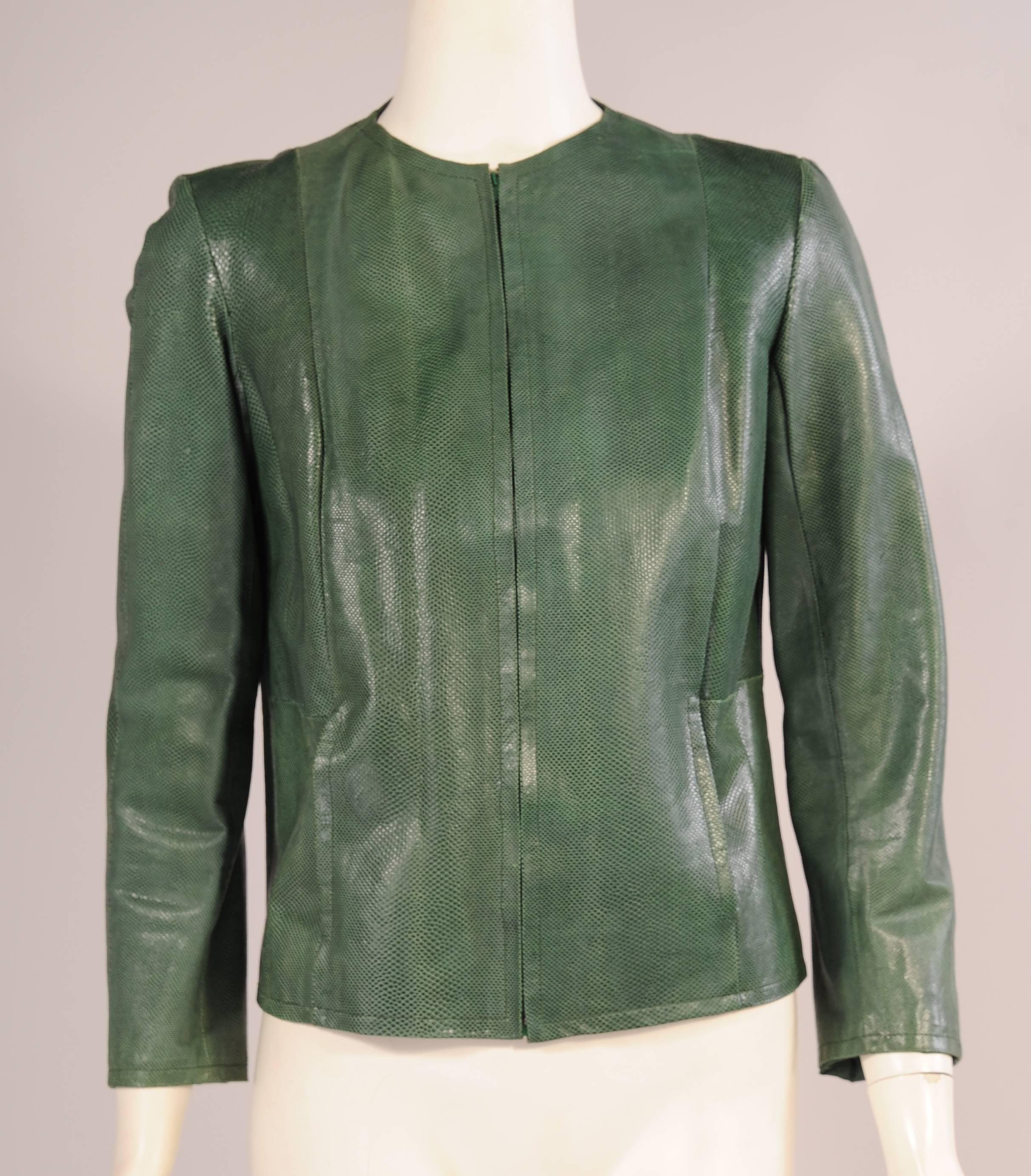 This spare and elegant jacket from Halston is collarless with a center front metal zipper and two pockets in the seams. Made from supple dyed green karung snakeskin it is in excellent condition. It is fully lined with matching green
