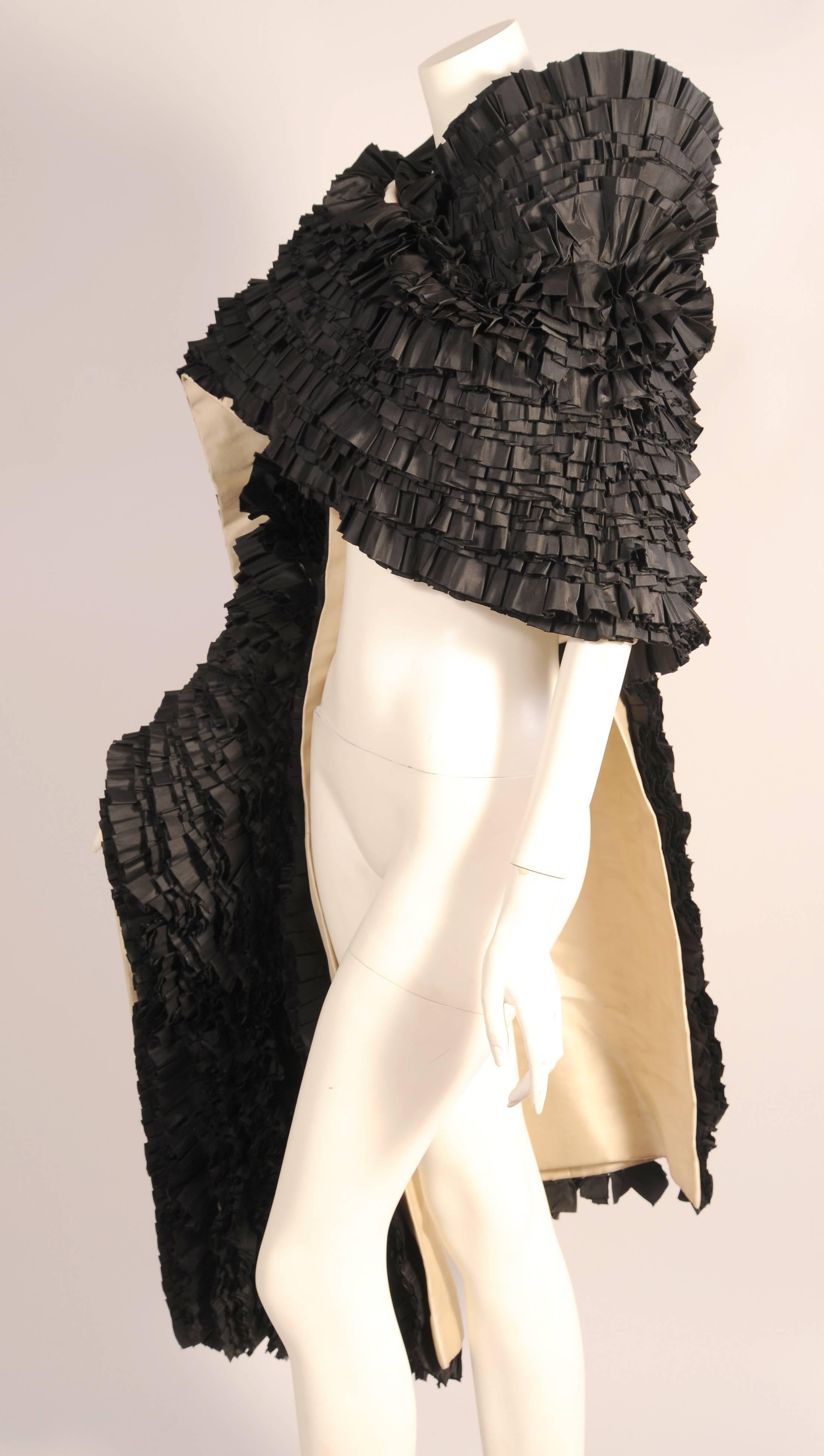 Forty rows of fine black silk ruffles add glamour and whimsy to this large stole or wrap made from ivory silk gazar. It is completely hand sewn and hand finished in the couture manner but there is no label. This piece would look equally fabulous