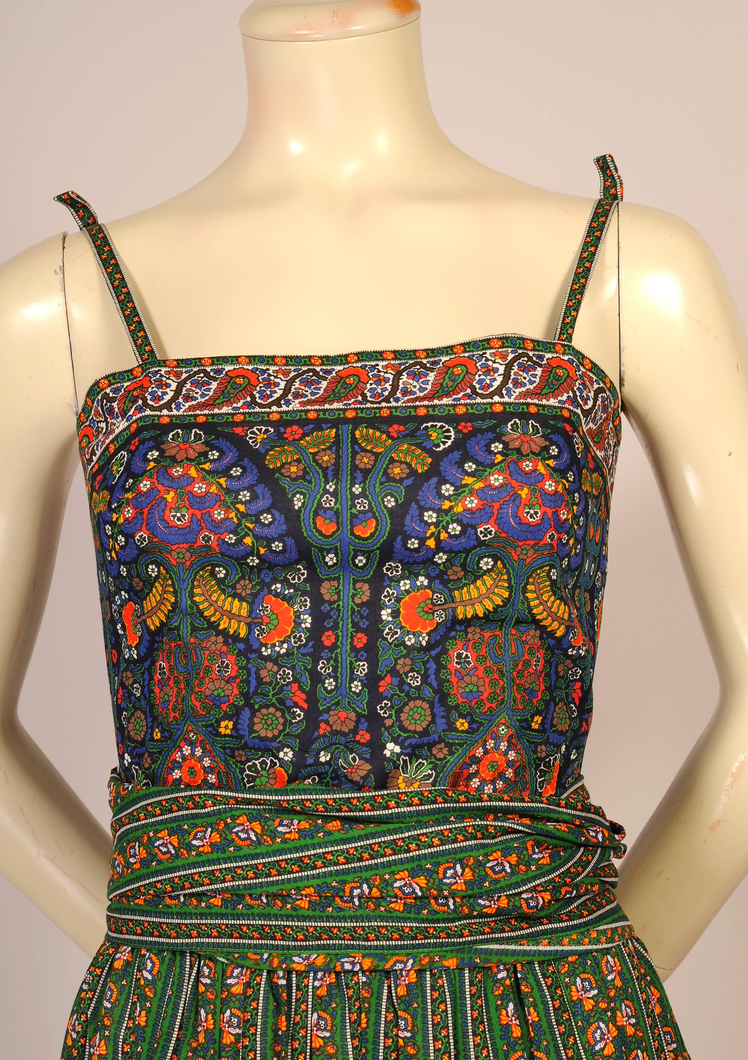 Tina Leser used a colorful cotton border print from the South of France for this charming two piece dress and shawl. The boned camisole style top is cut entirely from the border print. It has narrow straps with decorative bows, a center back metal