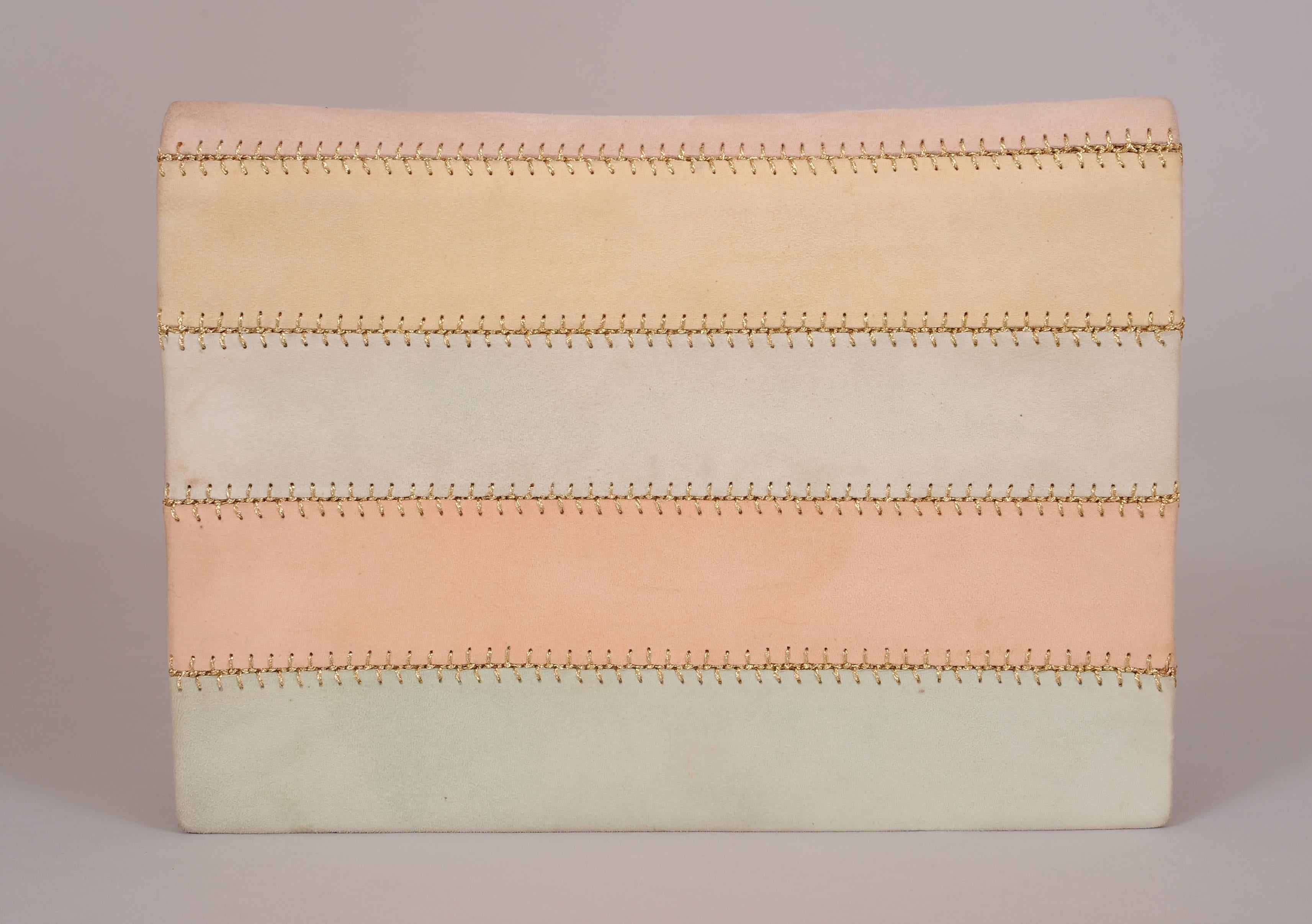 Andrea Pfister has designed a pale sorbet pink suede clutch with a rainbow of pastel colors on the front. These panels are joined with decorative metallic gold lacing. The bag has a slip pocket on the back, an optional pink suede shoulder strap, and