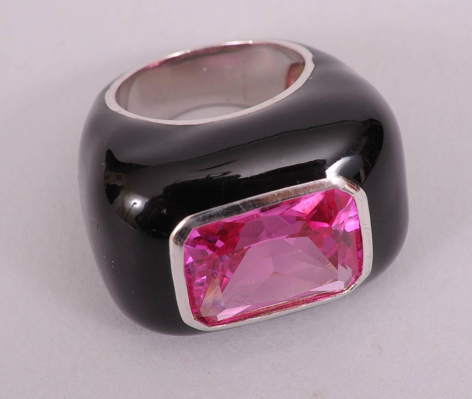 The striking combination of bright pink  and the glistening black enamel set off by sterling silver bands creates a very dramatic ring. This piece is large and impressive, the stone is approximately 12 carats. The ring is signed by the well regarded