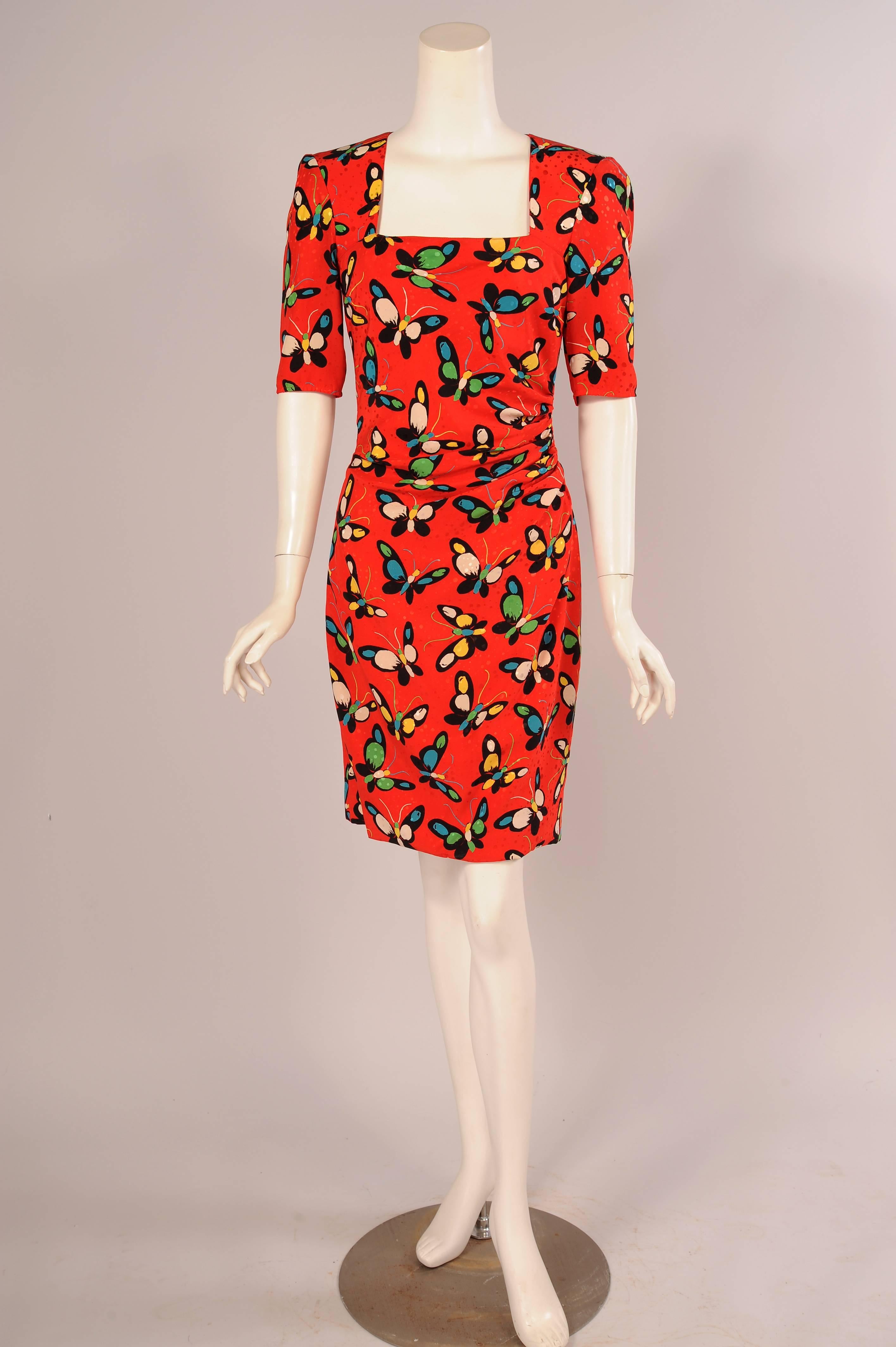 A cheerful and colorful butterfly print is combined with a woven dot pattern on this bright red dress from Ungaro Parallele. The dress has the signature sexy drape that Ungaro is known for with a square cut neckline and short sleeves. It has a