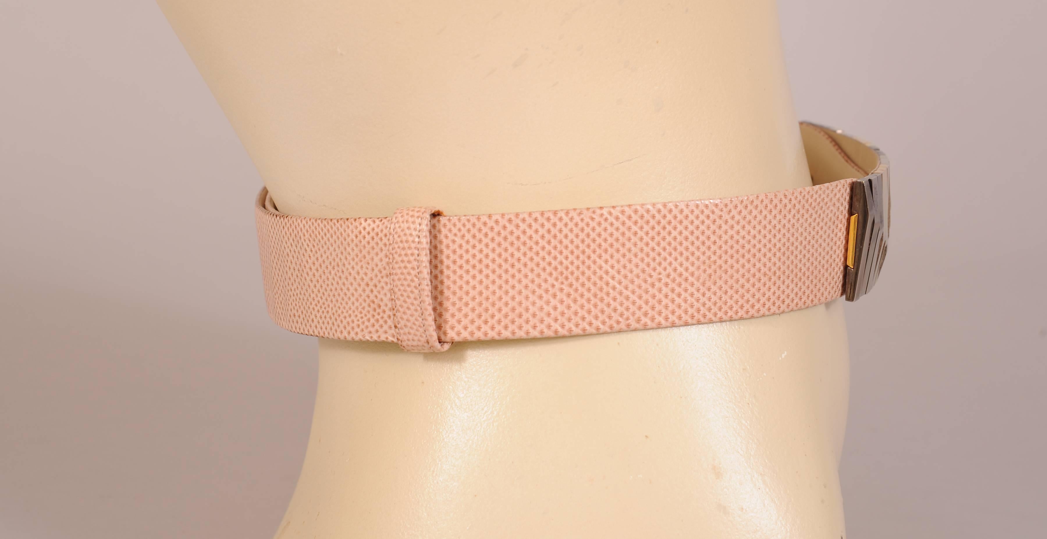 This belt is so chic with a two tone metal buckle on a pink/beige karung skin belt. The belt can be adjusted to accommodate a range of sizes from 22" to 37". It is signed Judith Leiber on the interior and it is in excellent