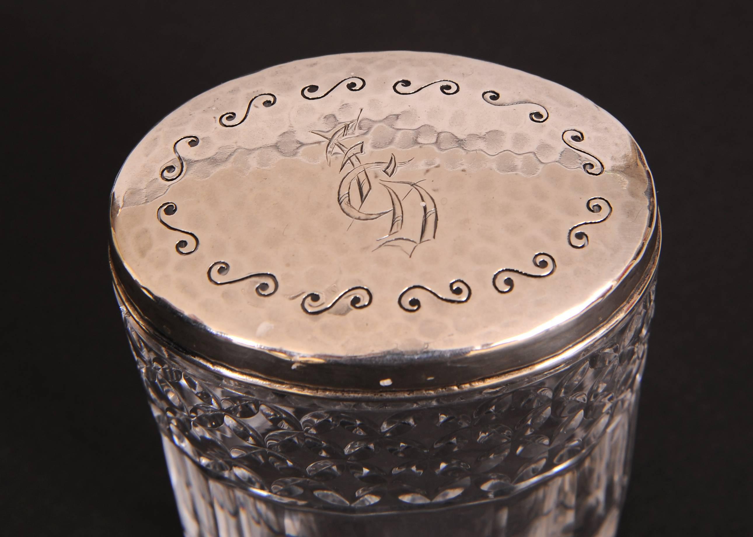 This stunning Tiffany & Co. dresser jar is the perfect size for cotton swabs.  The hammered sterling silver top has a pierced swirl decoration around the top edge and an oriental style monogram in the center. It is marked Tiffany & Co.