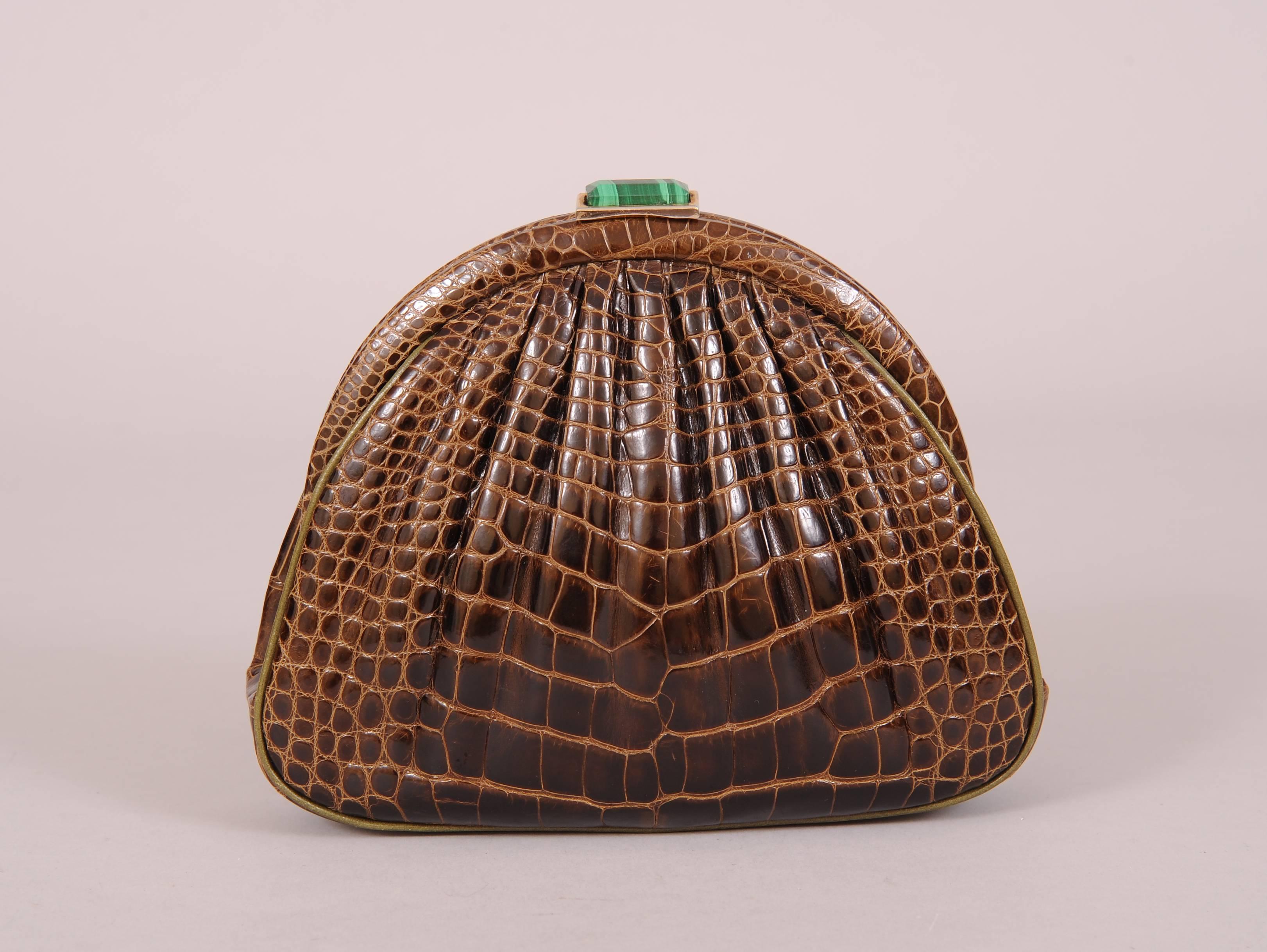 The partnership of Susan Bennis and Warren Edwards designed some of the most sought after and highly coveted hand made shoes and bags of the late 20th century. This rich brown alligator bag is accented with a malachite clasp and olive green leather