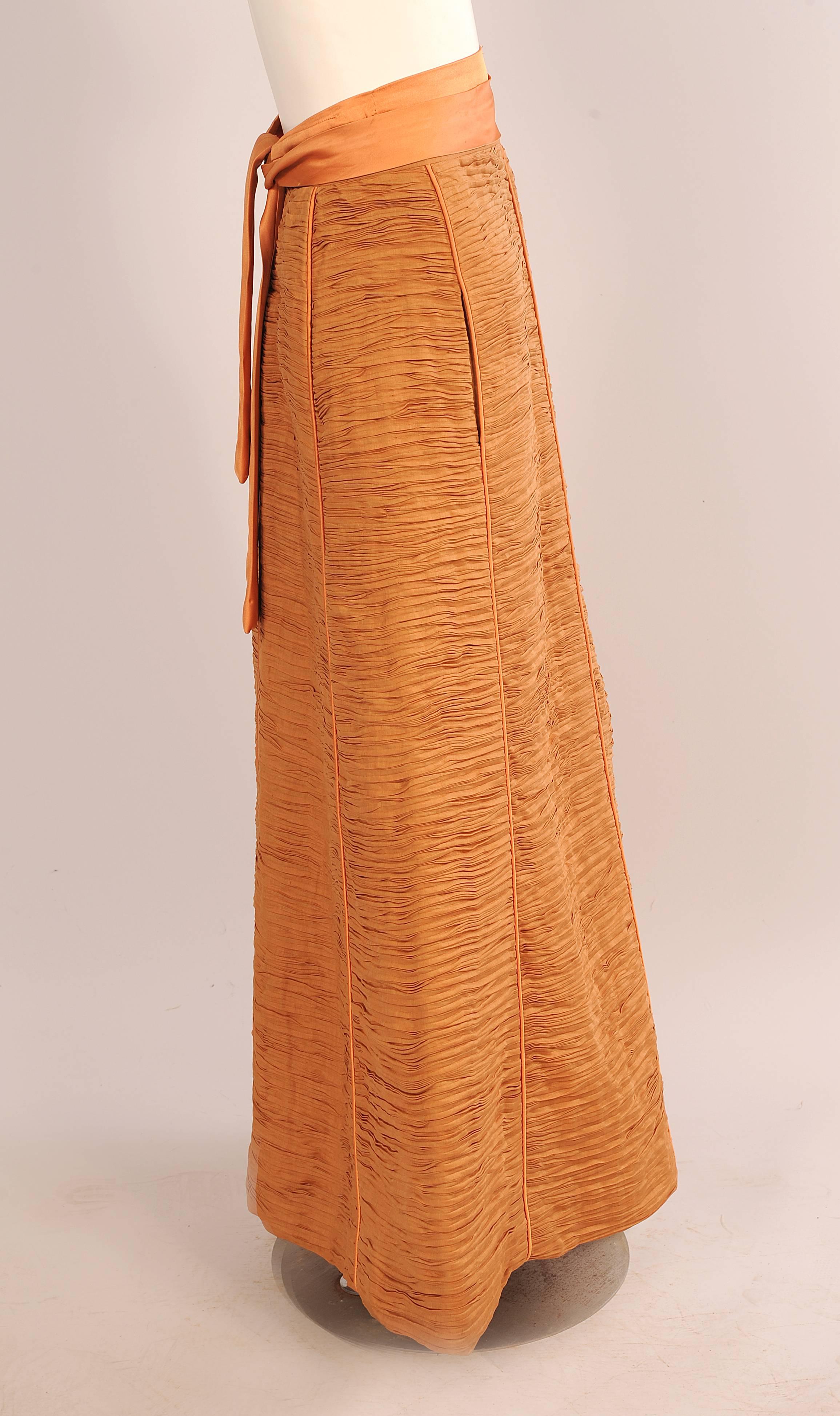 Sybil Connolly is most famous for her extremely rare pleated linen clothing. Each garment used nine yards of linen to make one yard of pleated linen. This stunning melon colored linen skirt is lined in matching silk. It is all hand finished in the