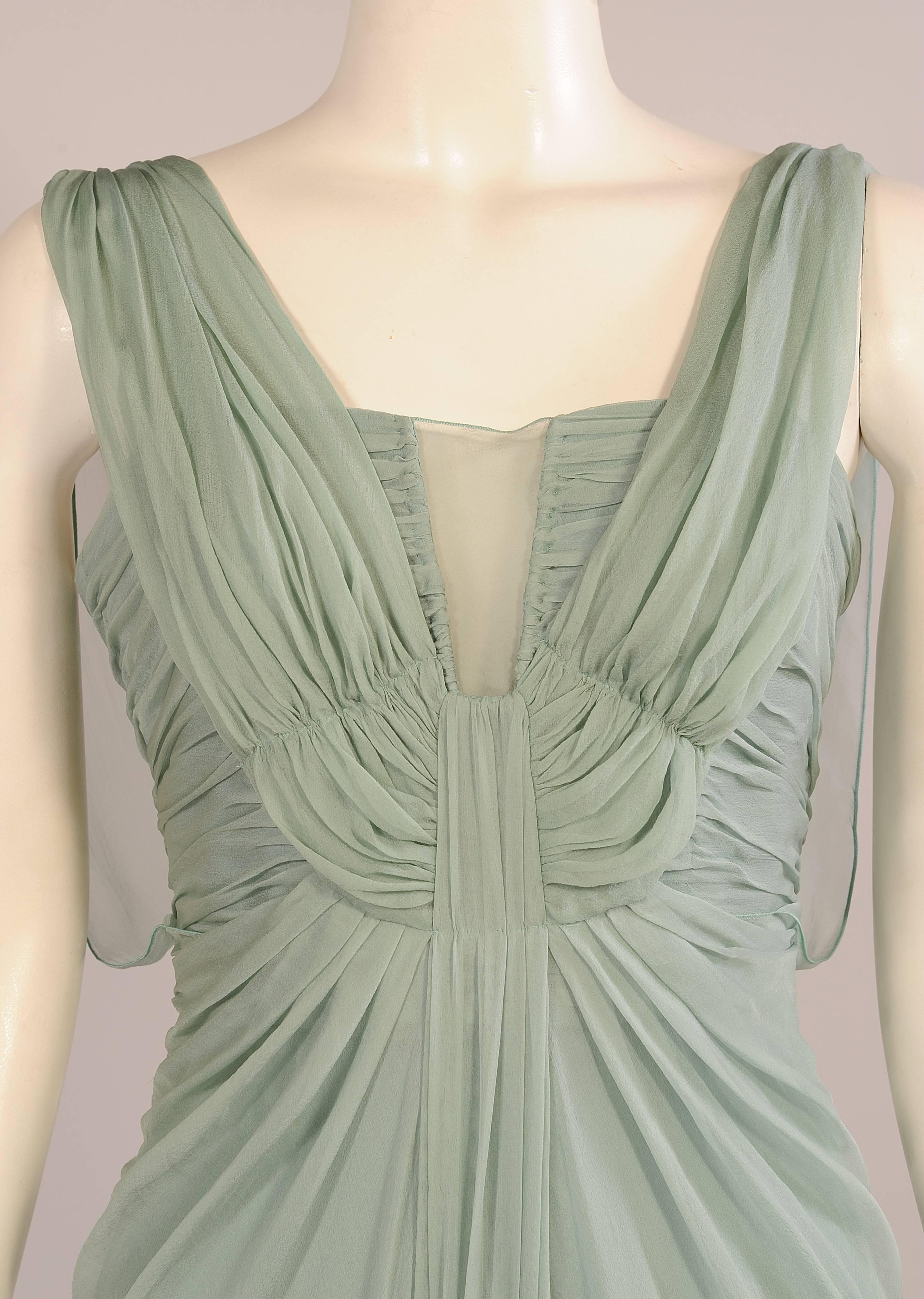 Elegant, feminine, glamorous are all excellent ways to describe this never worn Alberta Ferretti silk chiffon evening gown. It is the color of beach glass.  The boned bodice has narrow straps under the chiffon straps that continue to the center of