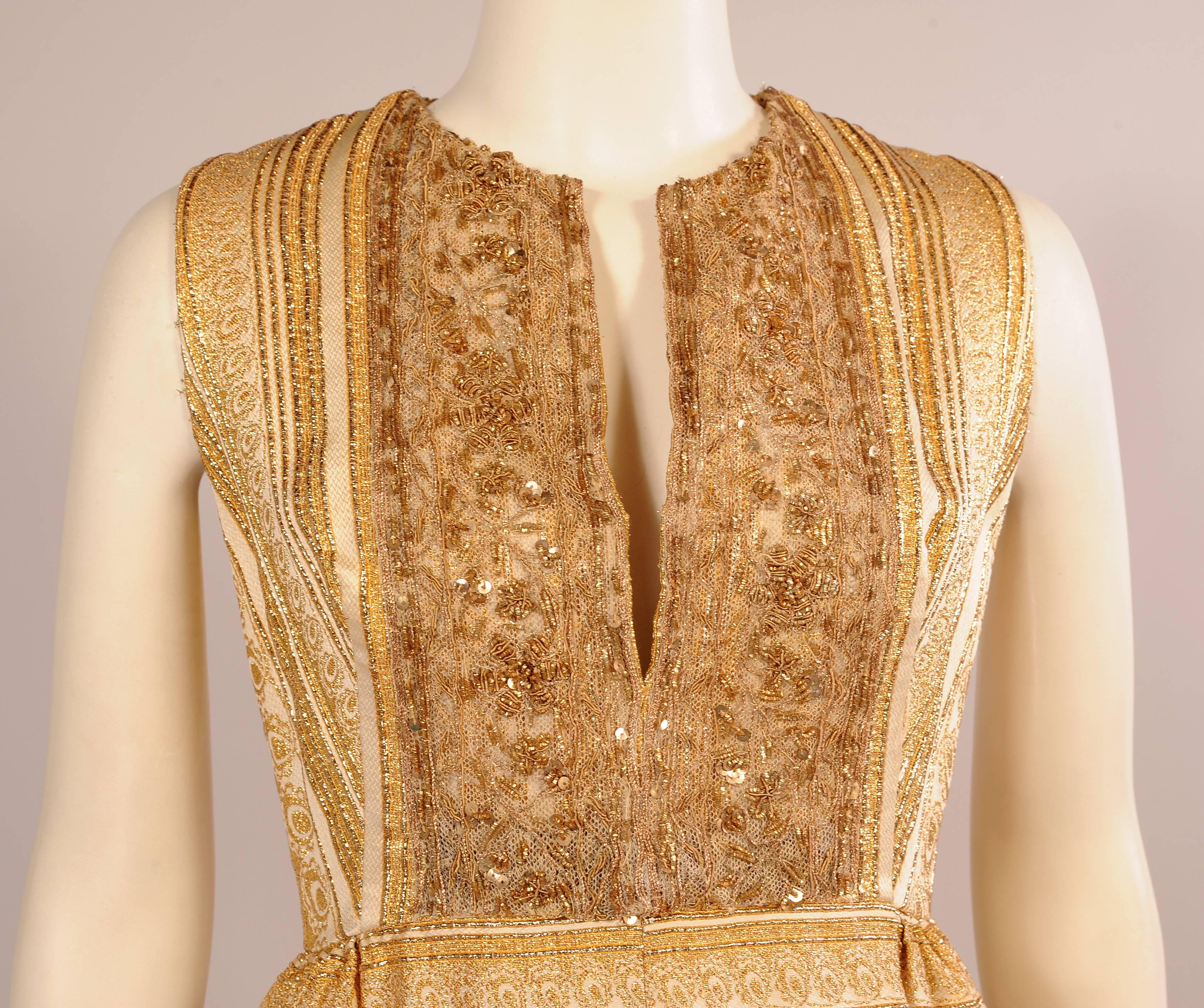 A Modern Couture Original retailed by Bonwit Teller in the 1960's this sparkling gold and cream woven lame dress has a jeweled tulle bodice with a plunging neckline and slightly raised waist line. The skirt is gently gathered over the hips and the