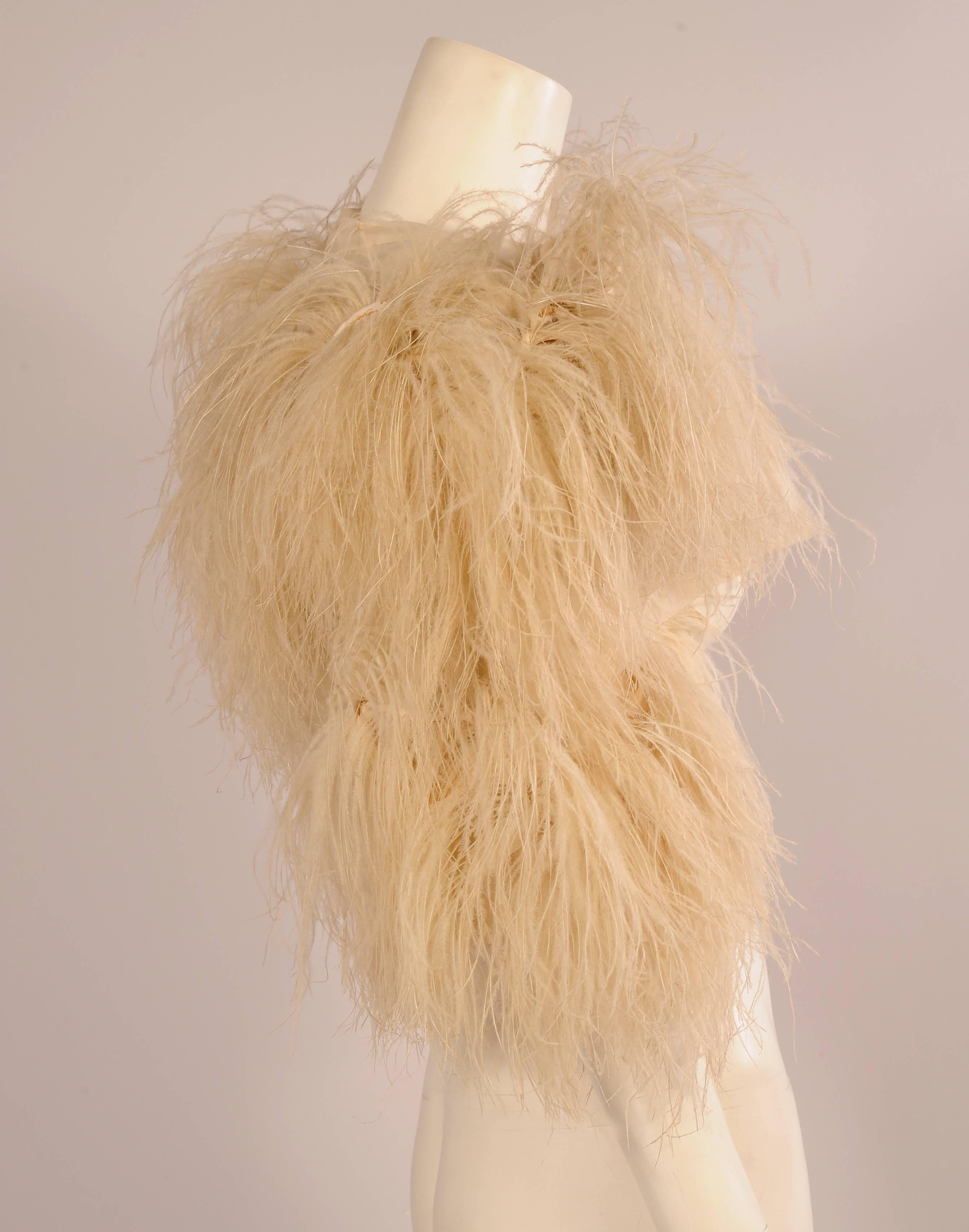 A little powder puff of an evening jacket, this rare 1920's haute couture piece from Paquin is made from cream colored silk organza covered with creamy ostrich feathers. It is all hand made and hand finished. The construction is quite elaborate with