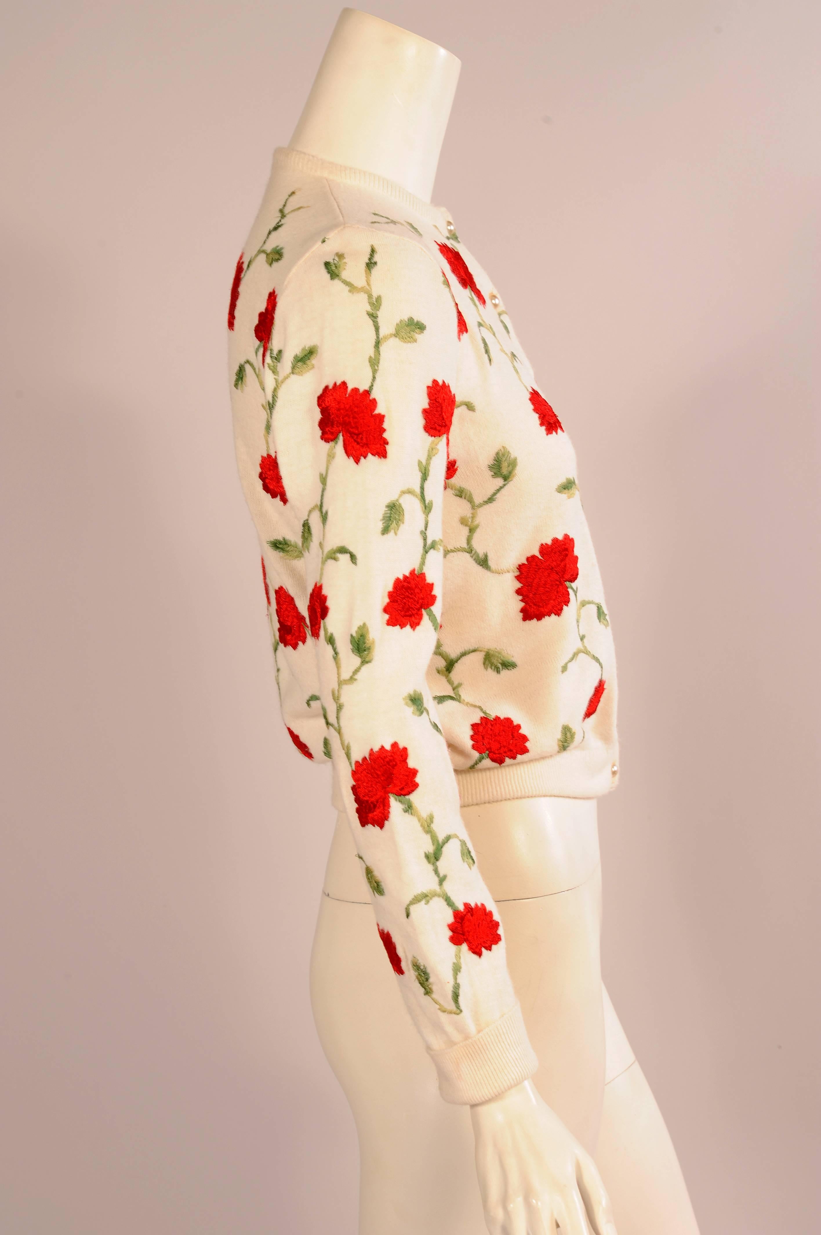 This creamy white cardigan is embroidered with green vines and leaves and cheerful red flowers. There are eight pearl buttons, and the waistband has been hemmed for a more flattering fit. It is in excellent condition.
Measurements;
Shoulders