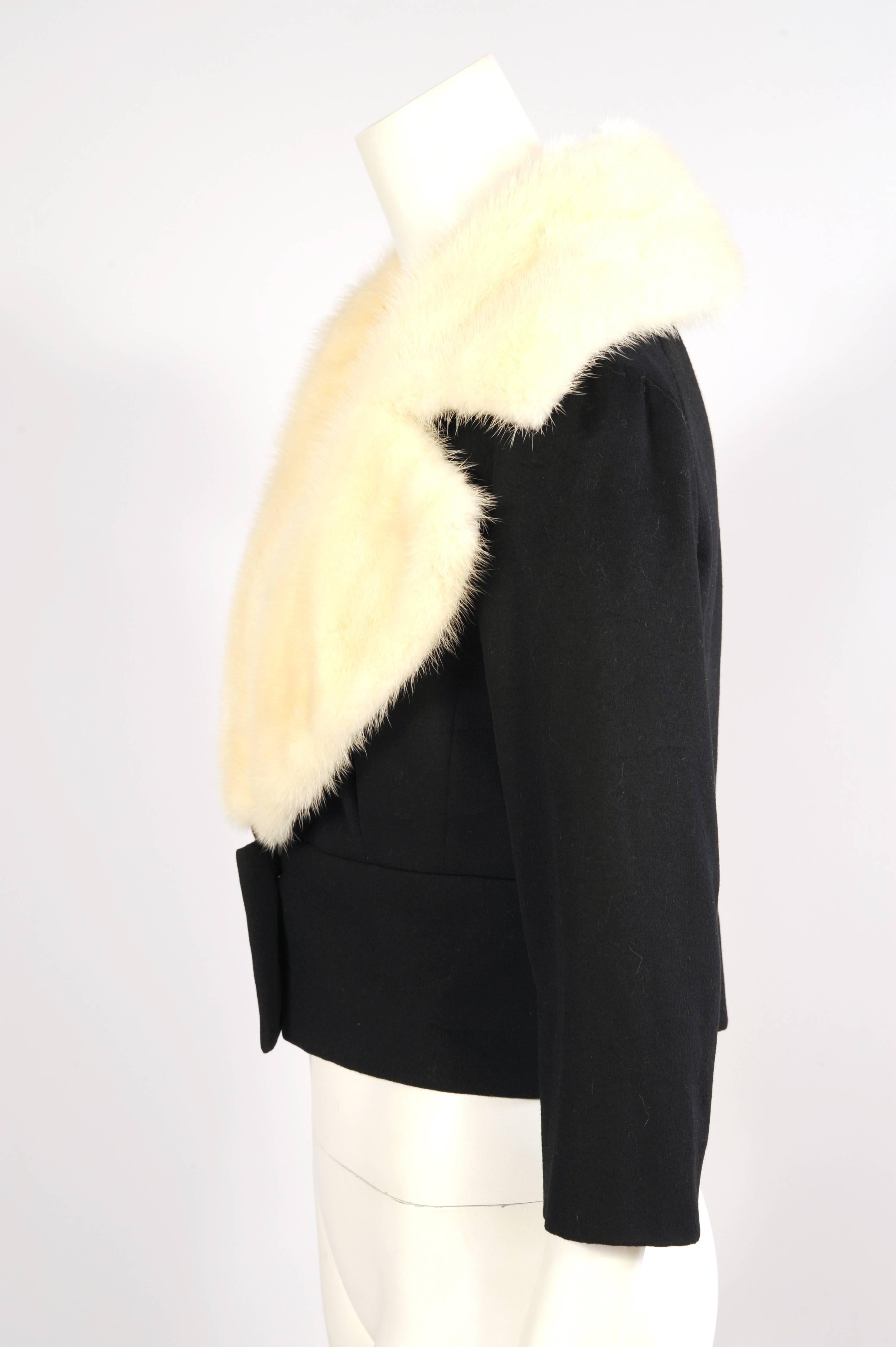 The softest black cashmere is combined with the most supple white mink in this numbered haute couture jacket from Jean Patou. The low cut neckline is wrapped with a generous white mink collar which tapers into a wide fitted waist band with two
