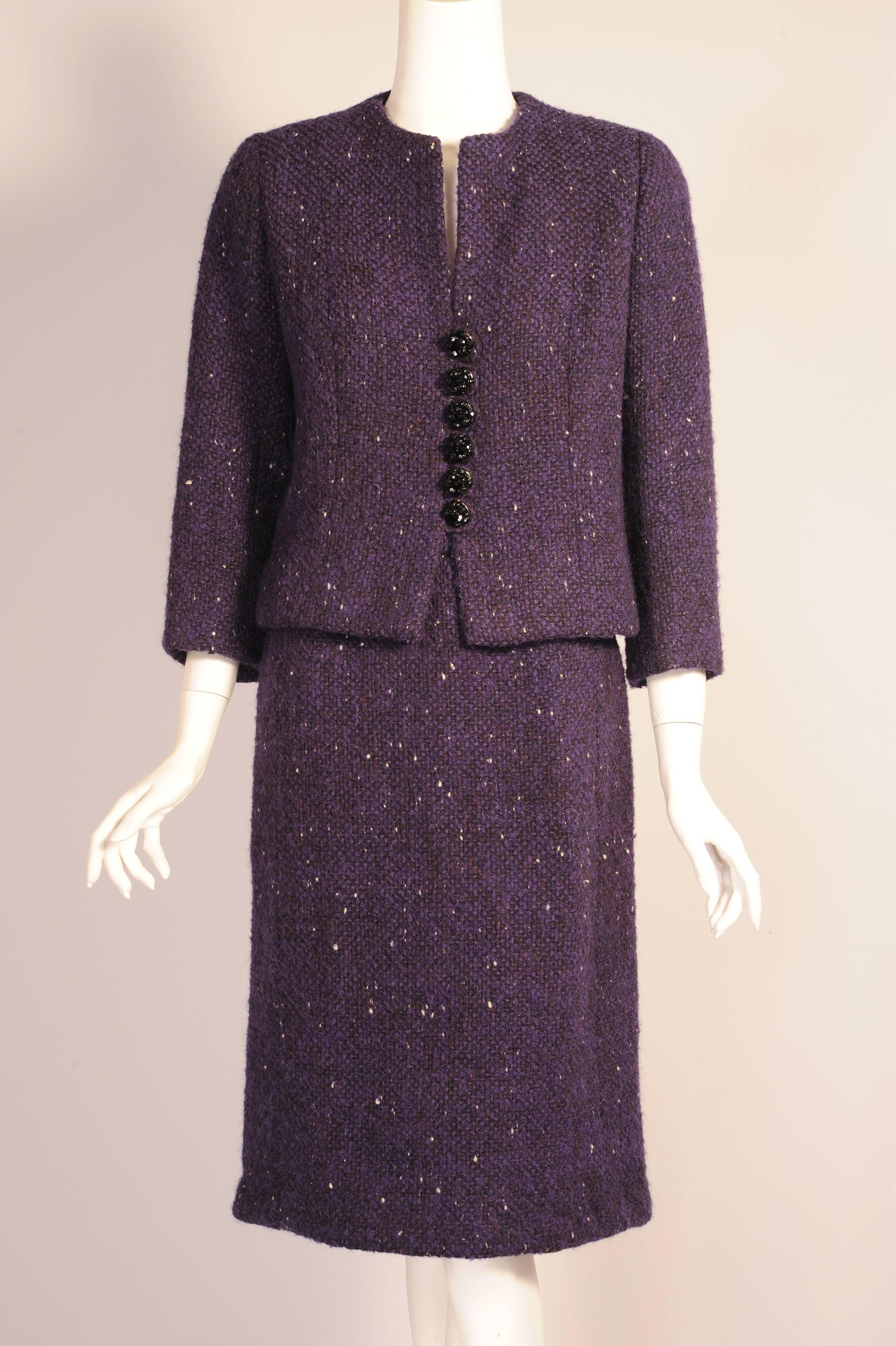 A classic 1960's design from the master of haute couture, this Balenciaga suit was designed for his Spanish Line, Eisa. The collarless jacket has black jet beads and fabric loops as the only ornamentation. The skirt sits at the natural waistline and