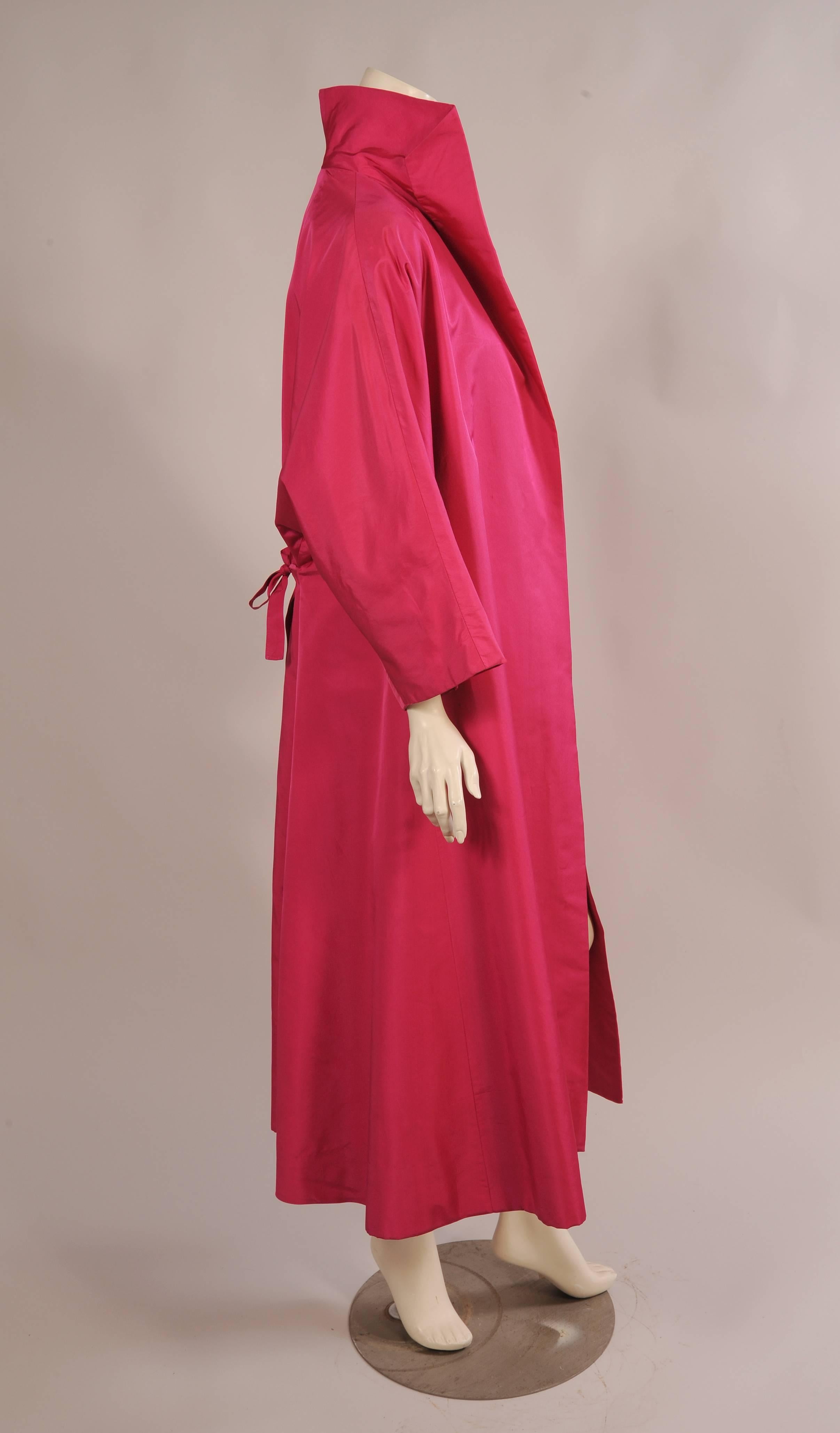 This stunning coat was designed by Hattie Carnegie in the 1950's for I. Magnin. The coat is the most beautiful shade of pink silk which would work well with so many other colors or prints. It has a shawl collar and a full swing cut with gathers at