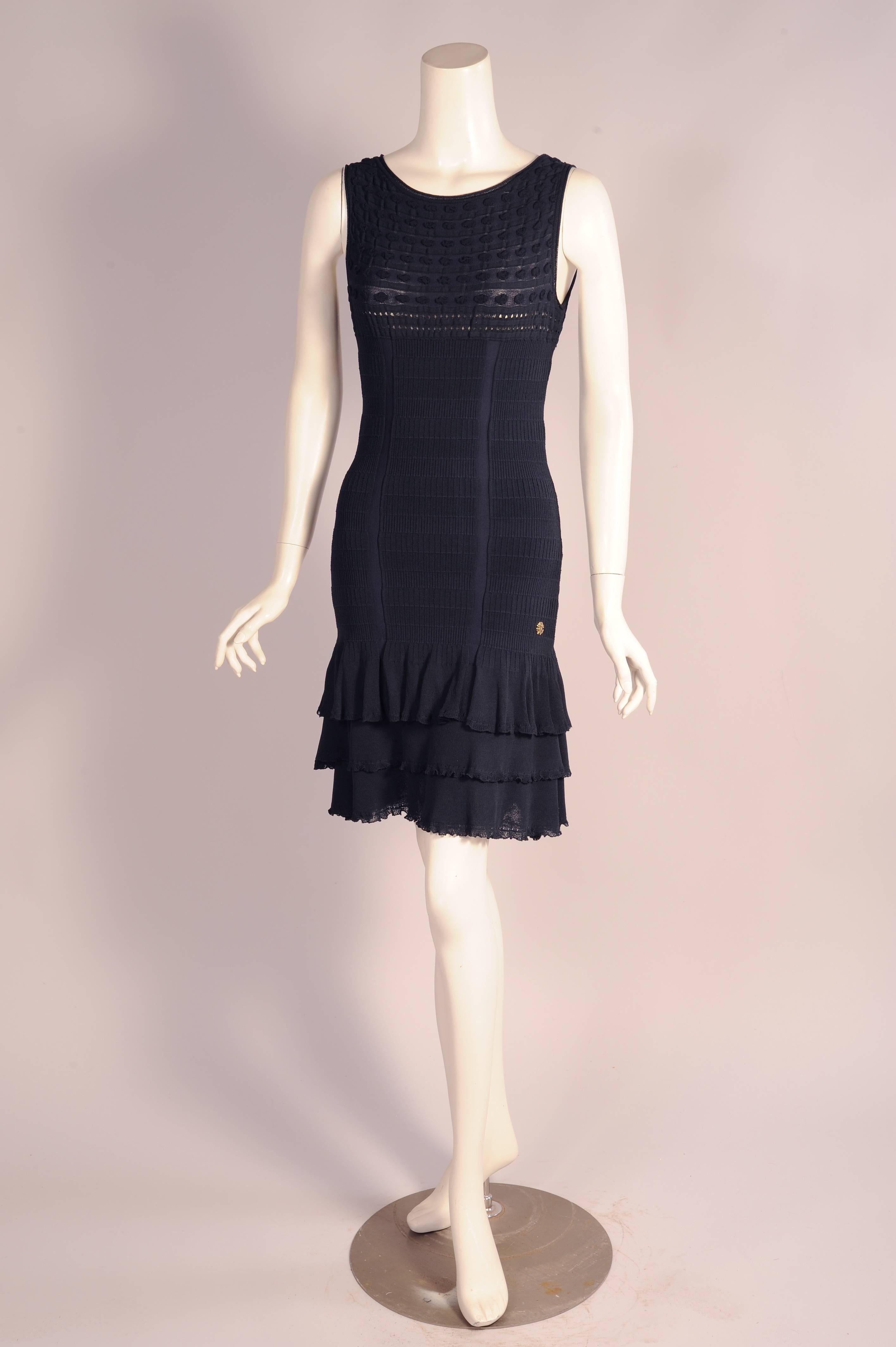 This sexy flirty little form fitting dress has several knit patterns adding extra interest. The dress has three different knit designs, one on the bodice, another vertical one on the torso and the ruffled hem. It has a Robrto Cavalli logo pin just