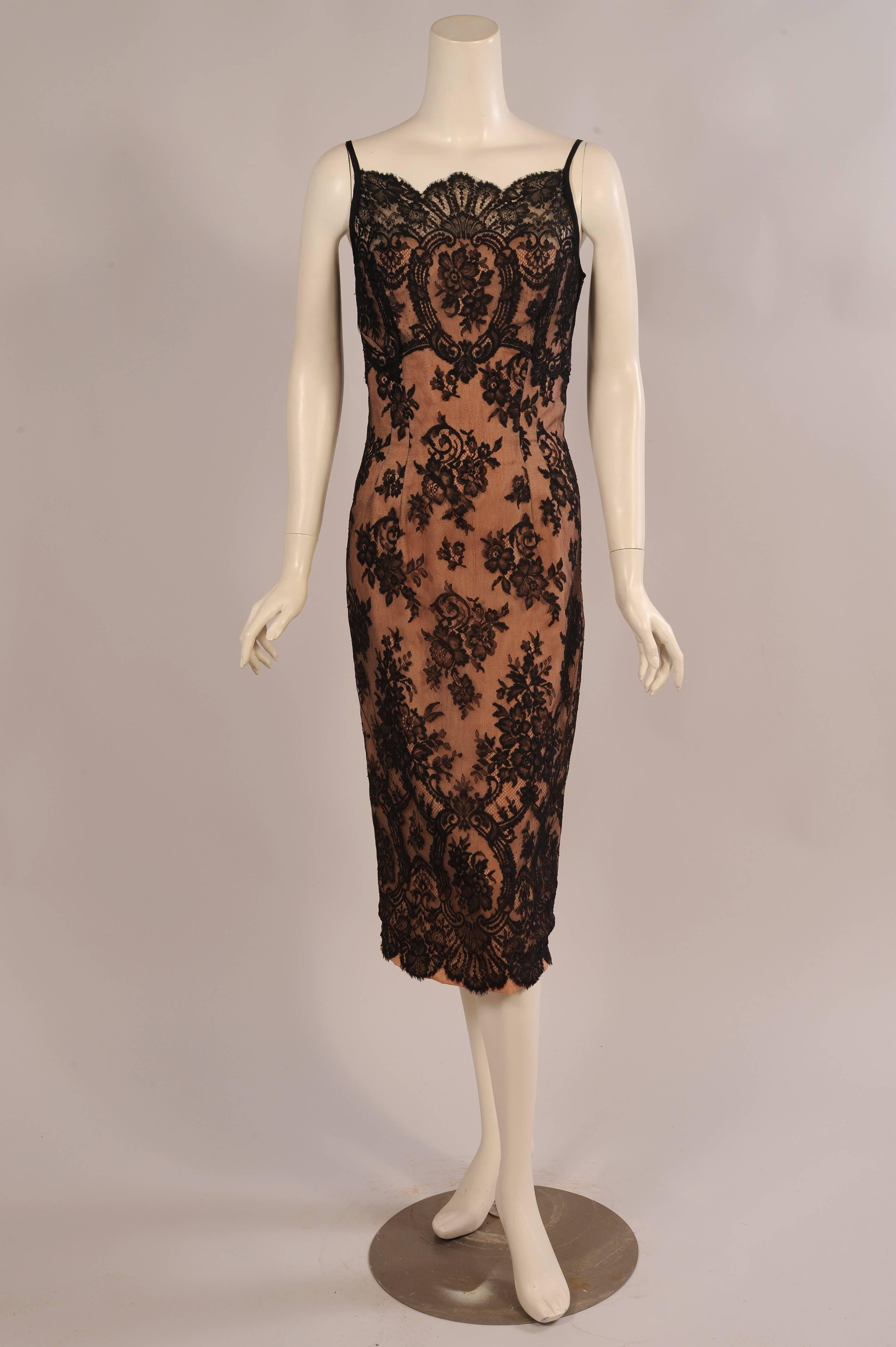 Gorgeous black lace over nude net and faille combines for this glamorous cocktail dress from Ceil Chapman. There are narrow black straps, a scalloped lace edge on the bodice and it is fitted through the torso. The skirt is narrow and the lace is