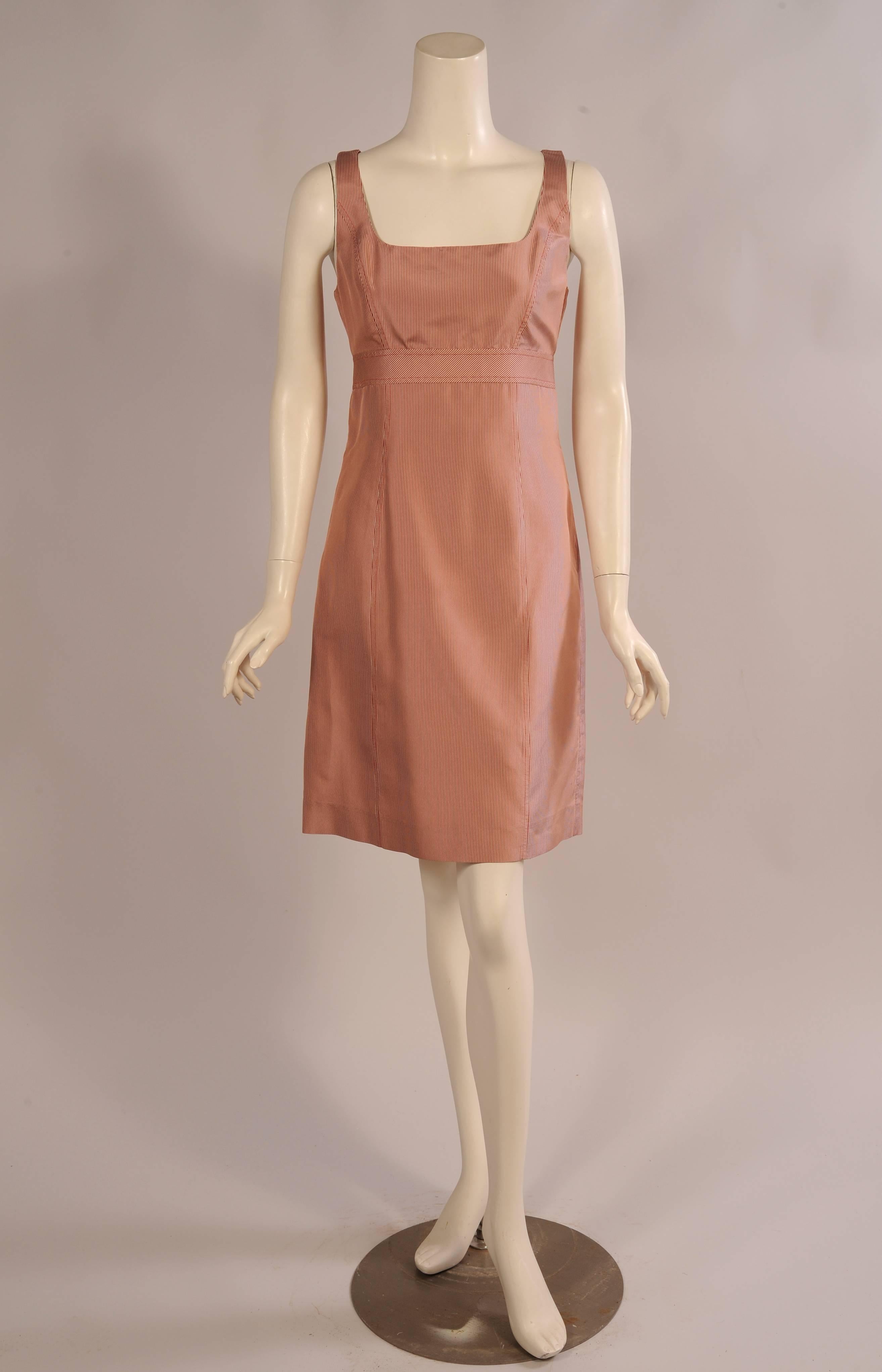 This sleeveless dress with a flattering scoop neckline has a raised Empire style waist band. It is defined by a wide flat band with the stripes running on the diagonal. The dress has a center back zipper, is fully lined and in excellent condition.