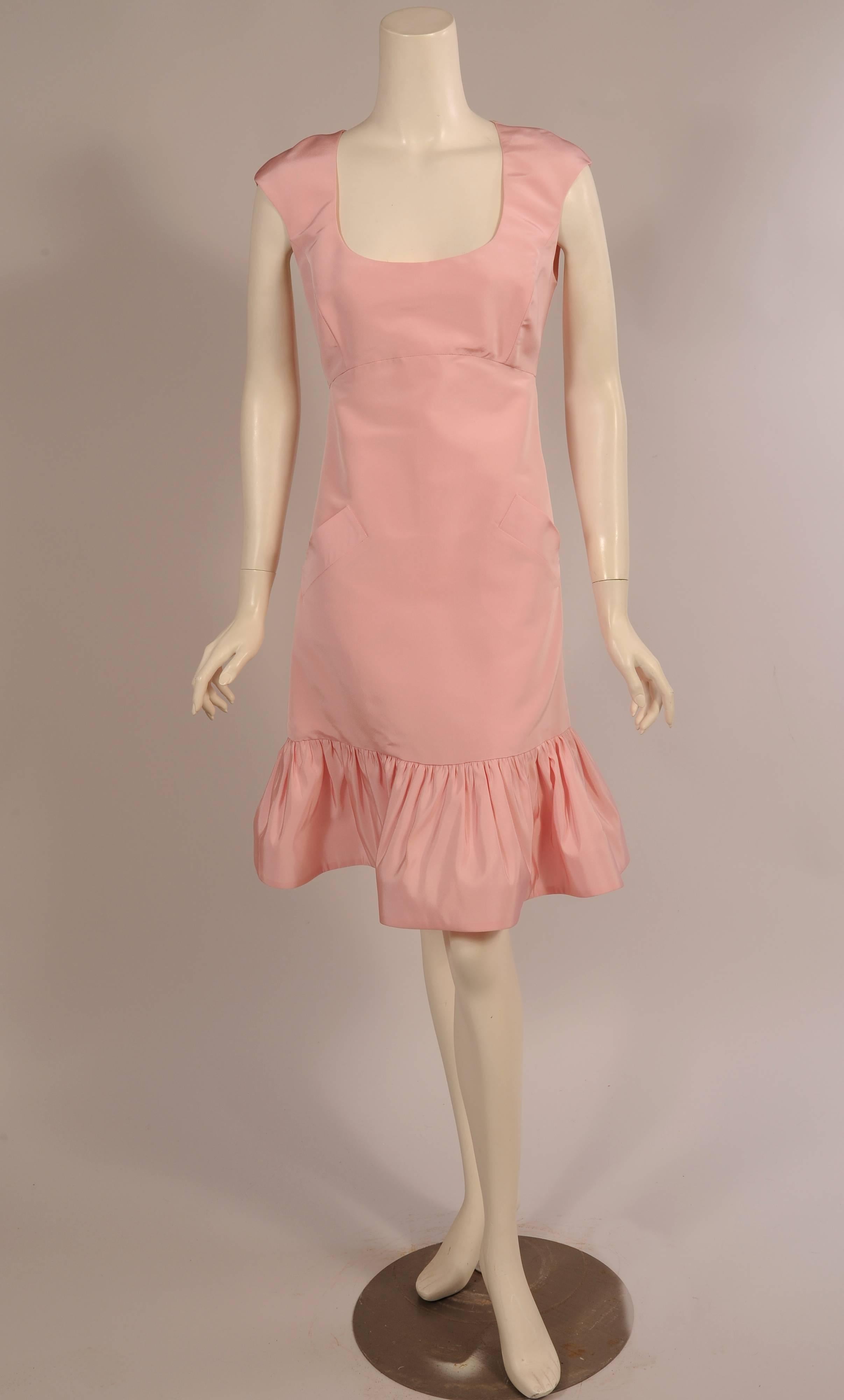 A beautiful pale pink silk faille dress with a scoop neckline, Empire waist, two slanted pockets and a flirty ruffled hem 
was designed by Osacr de la Renta. The dress has a center back zipper and is fully lined. It is marked a size 10 but please