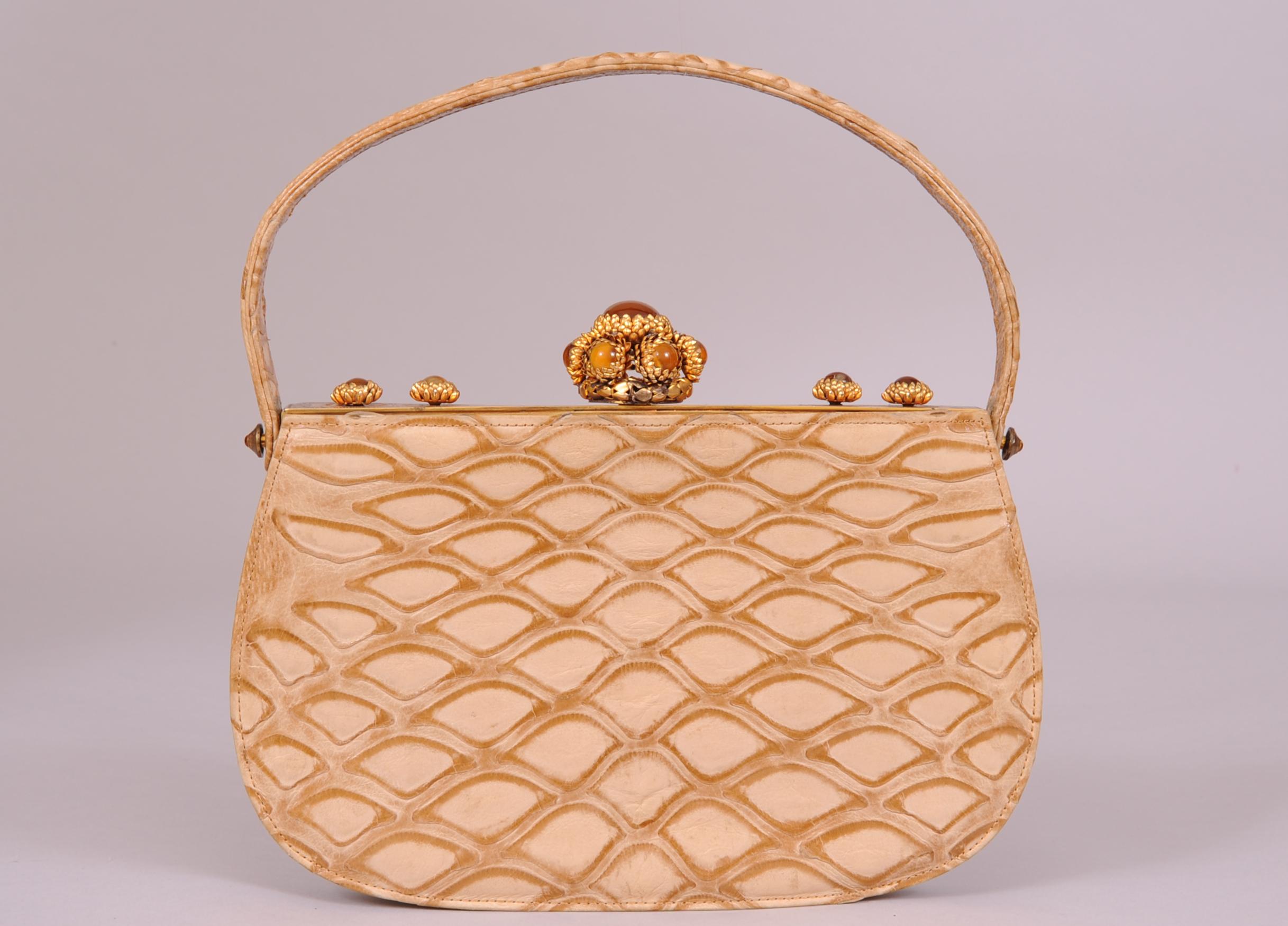 Chic, rare and unusual this striking Koret evening bag has the most eye catching jewelled frame I have ever offered for sale. The gold toned frame has cabochon stones set in gold toned flower shaped petals. There is one large clasp of stones at the