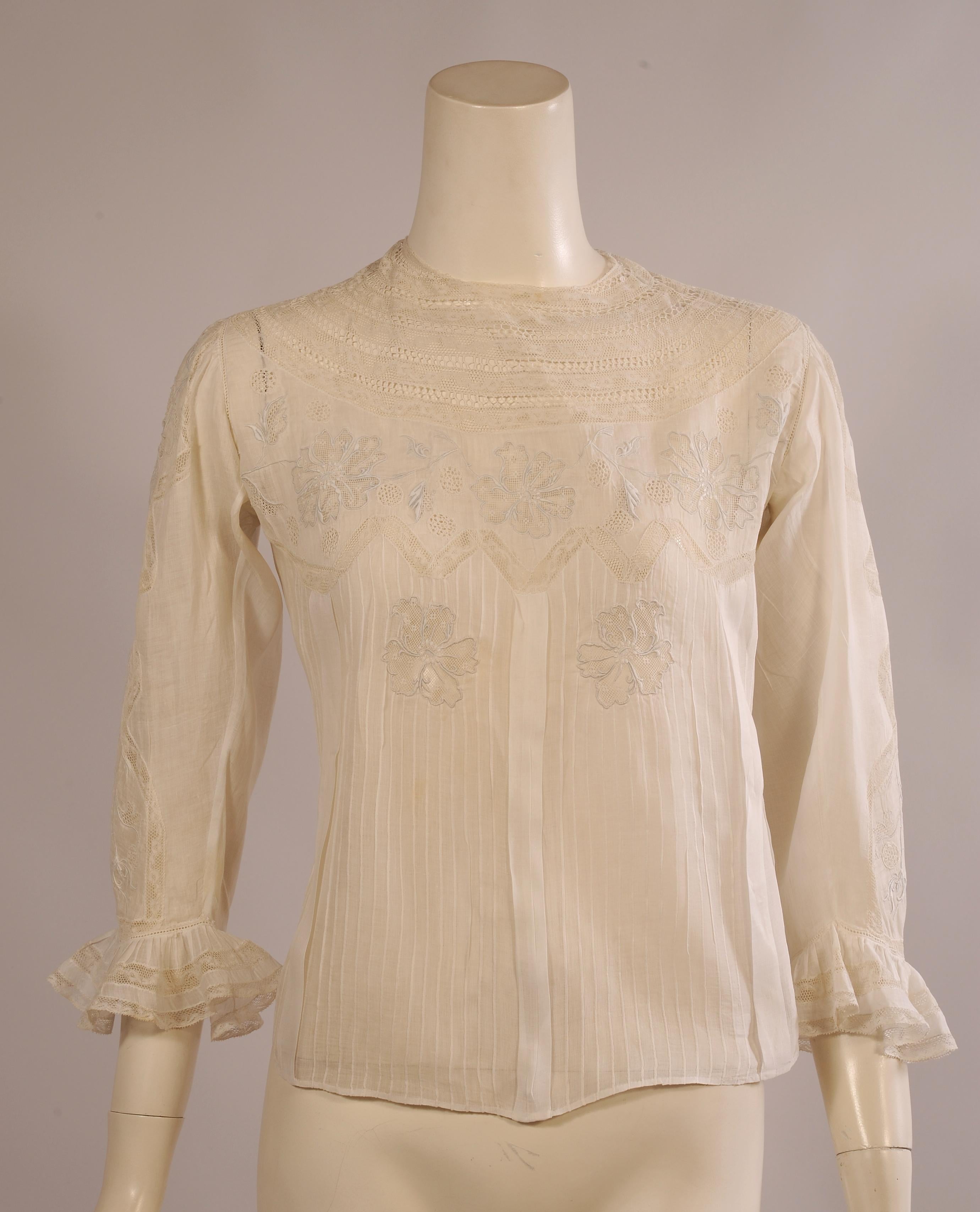 Hand made in Switzerland and retailed on the via Condotti in Rome this handkerchief linen blouse has the most beautiful embroidery and drawn work. The blouse has a wide lace and drawn work yoke and a beautiful panel of hand embroidery above another