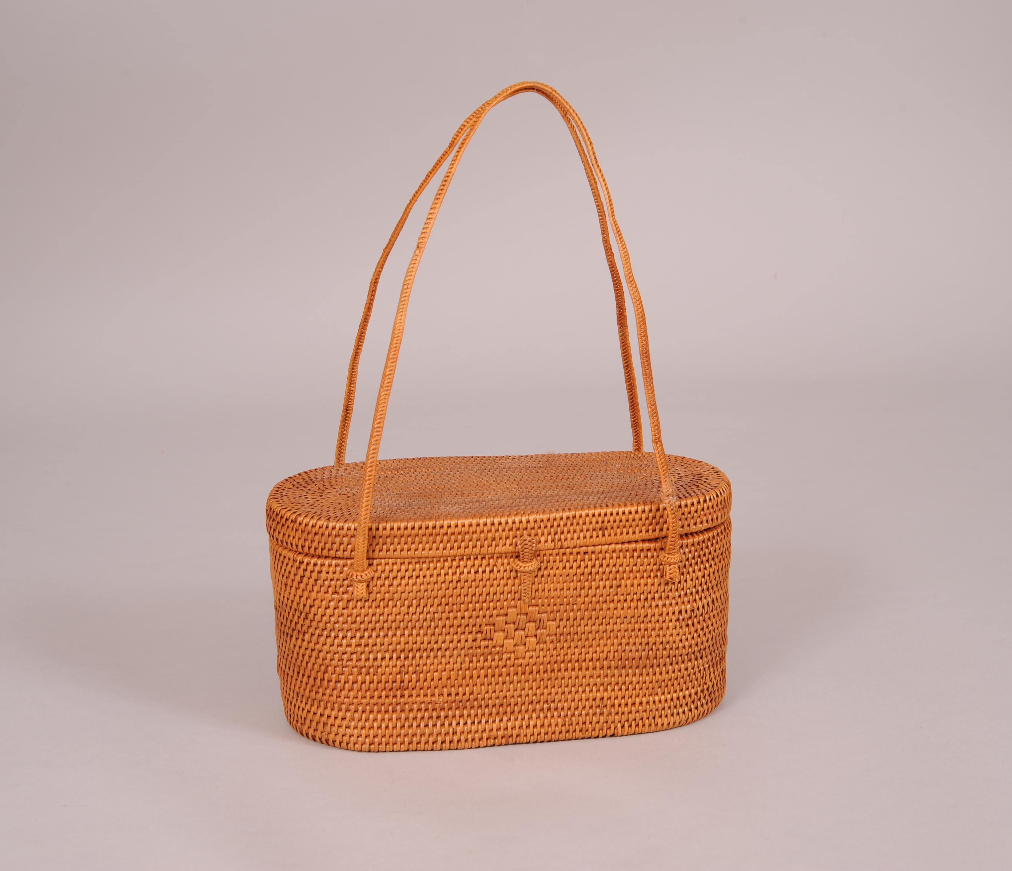 This beautifully hand woven straw bag is an oval shaped box bag from the 1950's. The top is attached with straw 