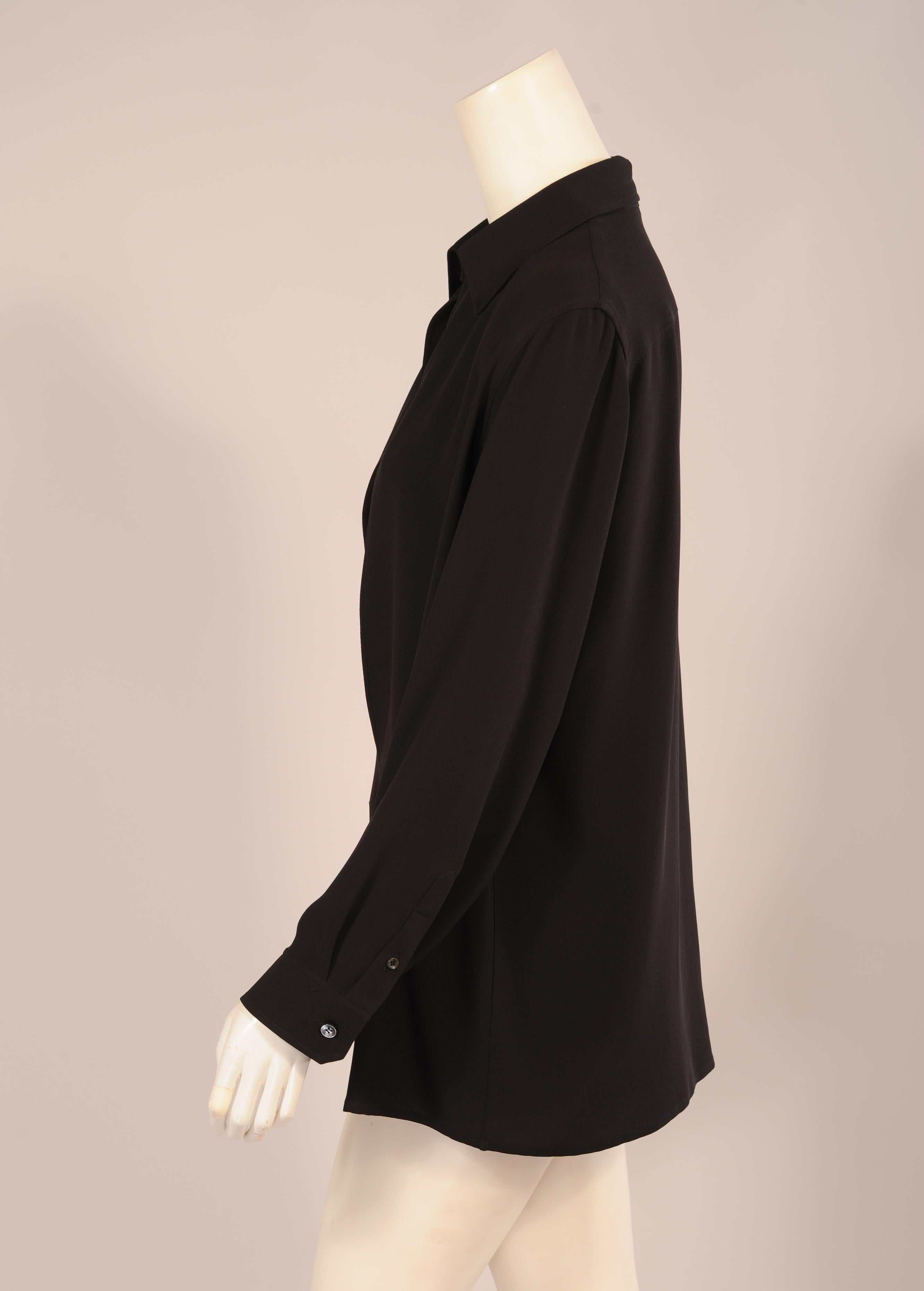 So chic and elegant, this understated and oversized black silk tunic from Hermes has a pointed collar and two button cuffs.  The distinguishing design element that makes it so wonderful is the very deep opening at the center front where the button