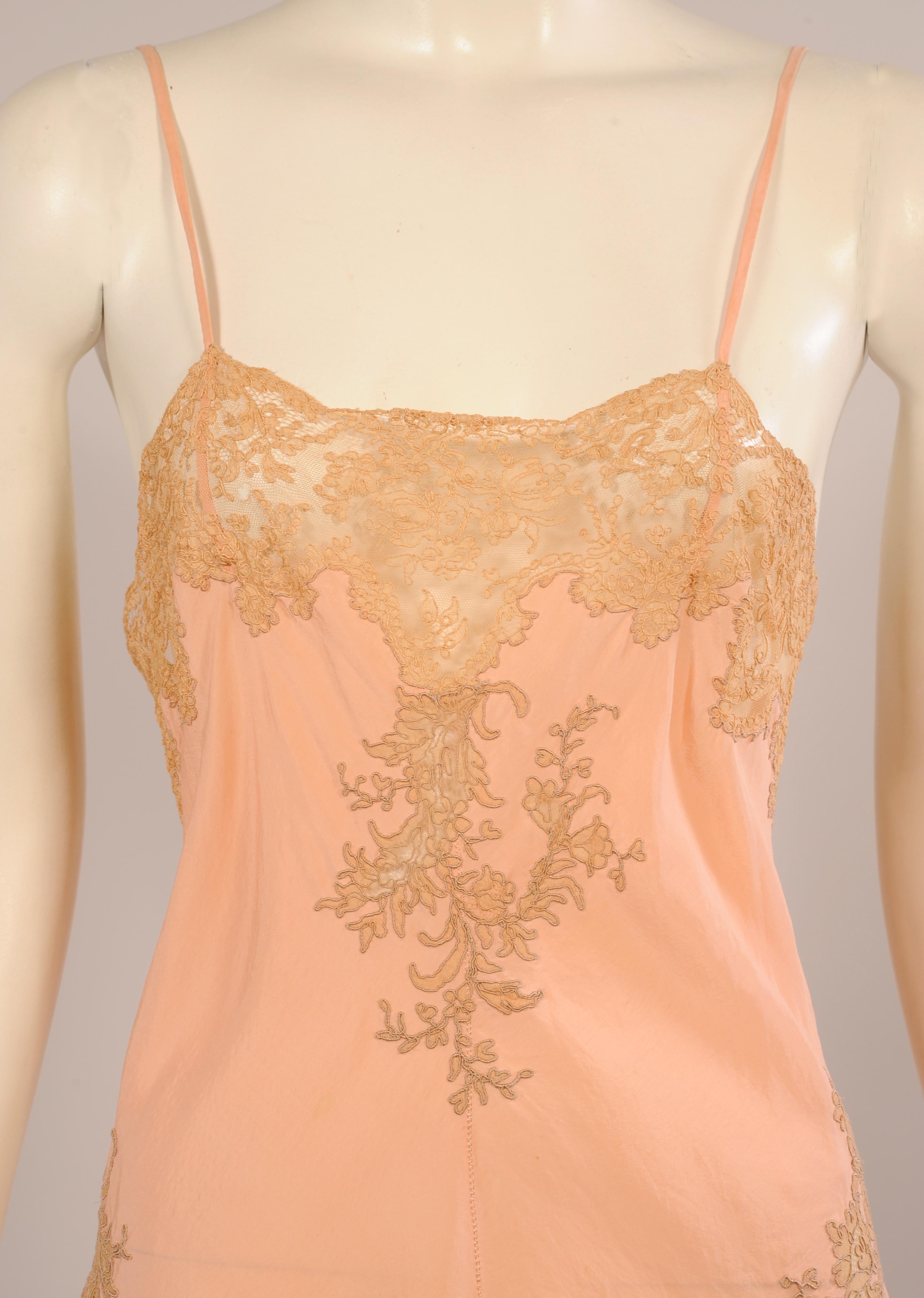 Handmade Alencon lace is lavished on this beautiful completely handmade lingerie pink silk slip. There are narrow straps above a wide band of lace at the top with a beautiful lace applique at the center and over both hips. A deep flounce of double