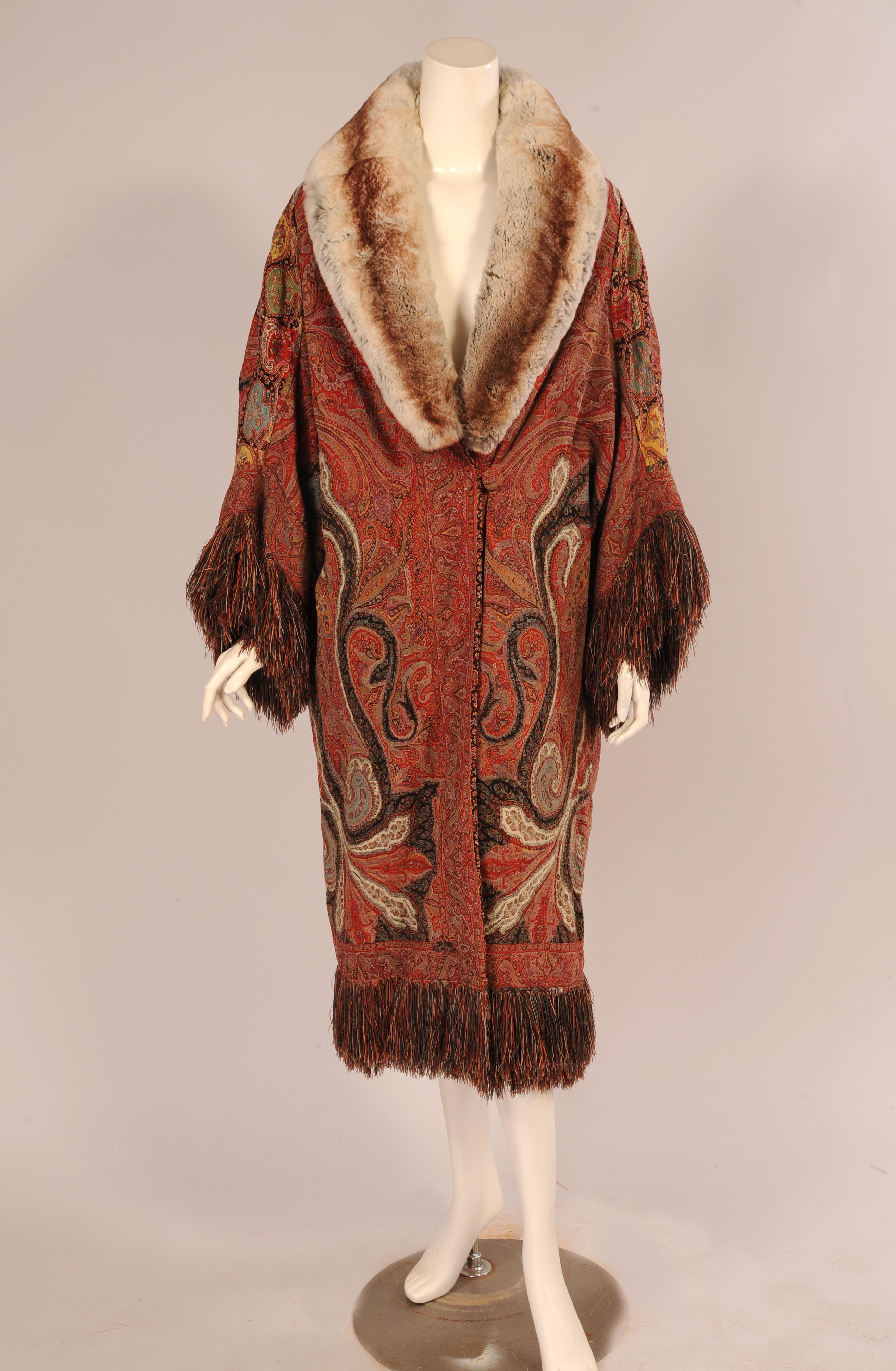 A beautiful antique handmade wool Kashmiri paisley shawl, made in India has been used to make this dramatic 1920's Coat with a chinchilla collar and multi-color silk fringe trim. The pattern has been laid out to great advantage, making the best use