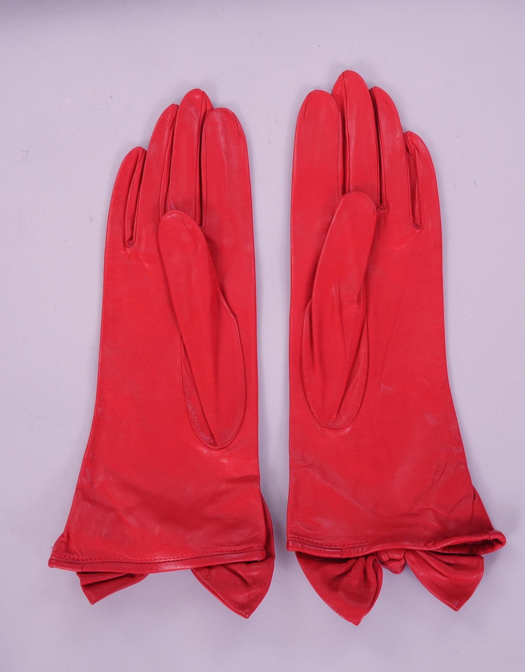 These butter soft red leather gloves designed by Carlos Falchi have a wonderful leather bow and knot at the wrist. They are lined in red silk and marked a size 7 1/2.. Never worn, they are in pristine condition. 