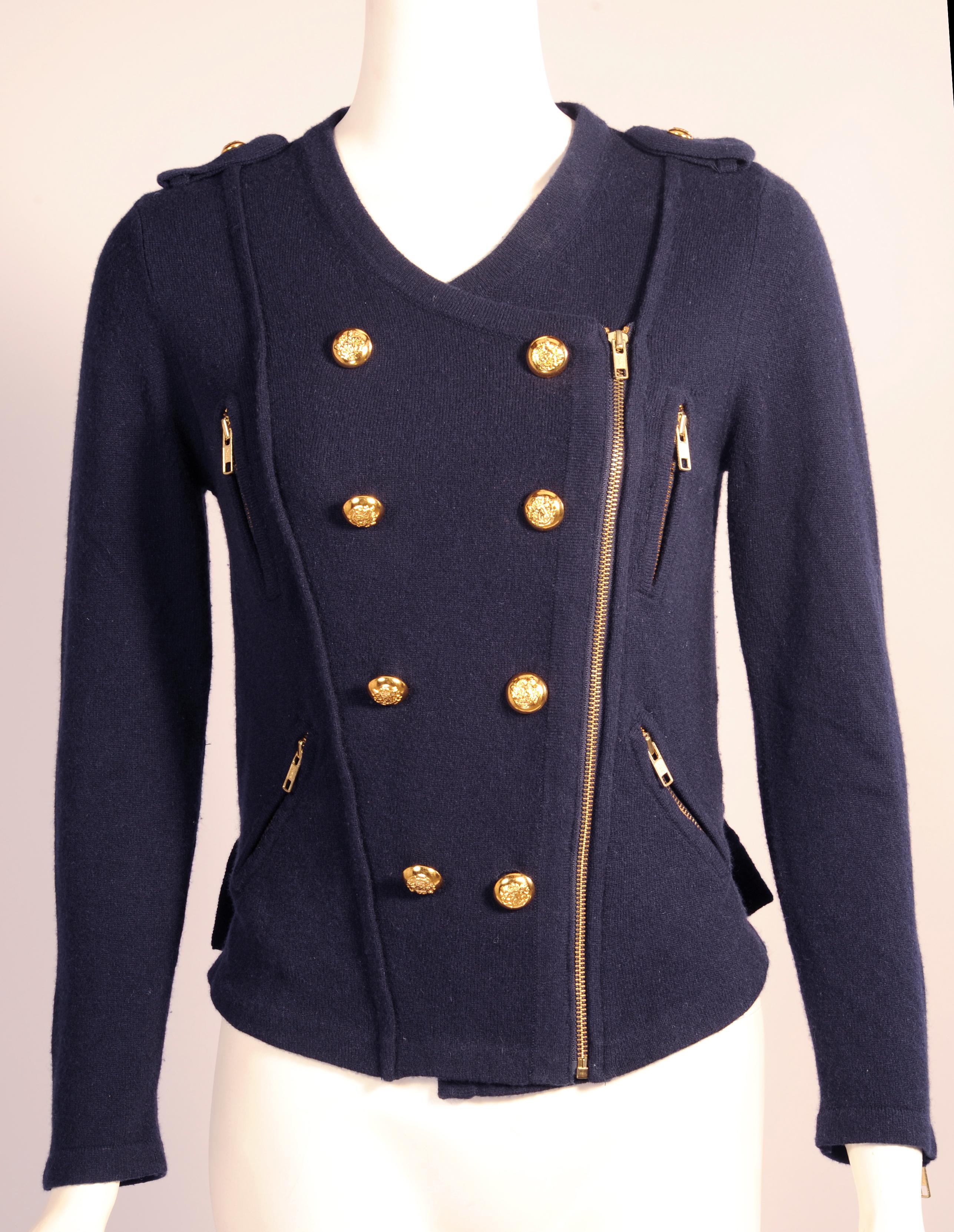 Military inspiration is on display in this double breasted sweater with gold toned buttons and epaulets. The sweater also has a left side zipper, four zipper pockets, zippers on both sleeves, and two buckles on the back to adjust the fit of the