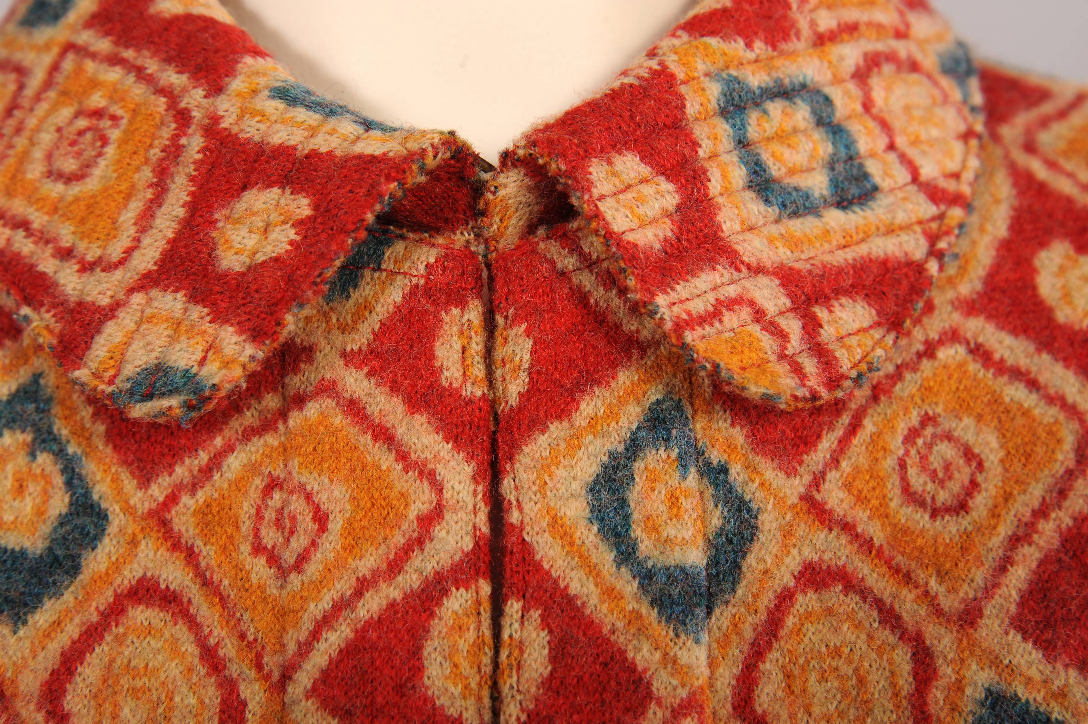 A cheerful combination of red, yellow, blue and beige is used for the circles and squares in the pattern of this woven wool jacket. It closes with hooks and eyes and the interior seams are all bound. It is in excellent condition.
Measurements; 