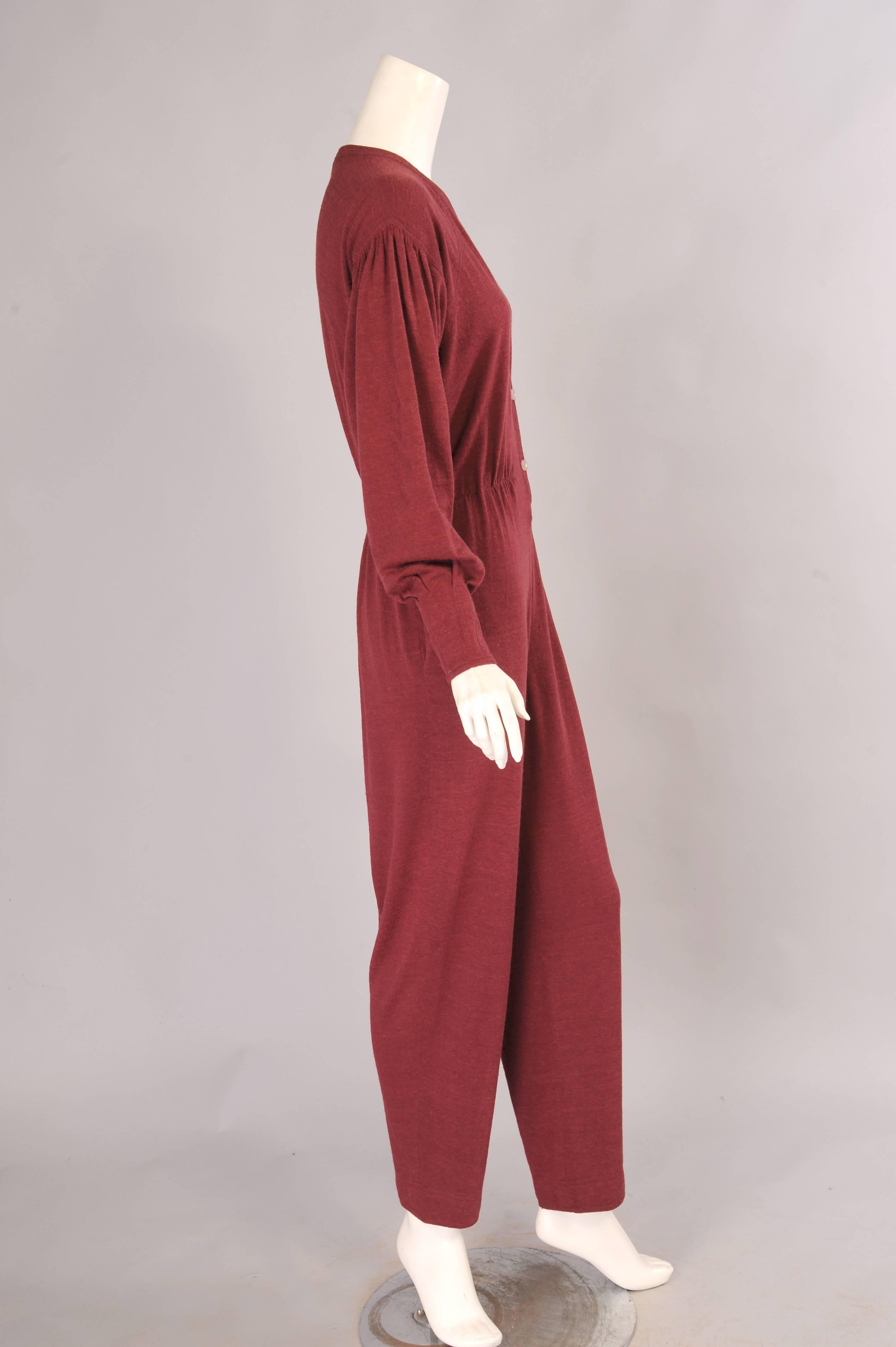 Effortless dressing at the very best level of comfort and style, this wool blend jumpsuit has a three button closure, a single button and loop at the wrist, an elasticized waist and two hip pockets. It is in excellent condition and marked a vintage