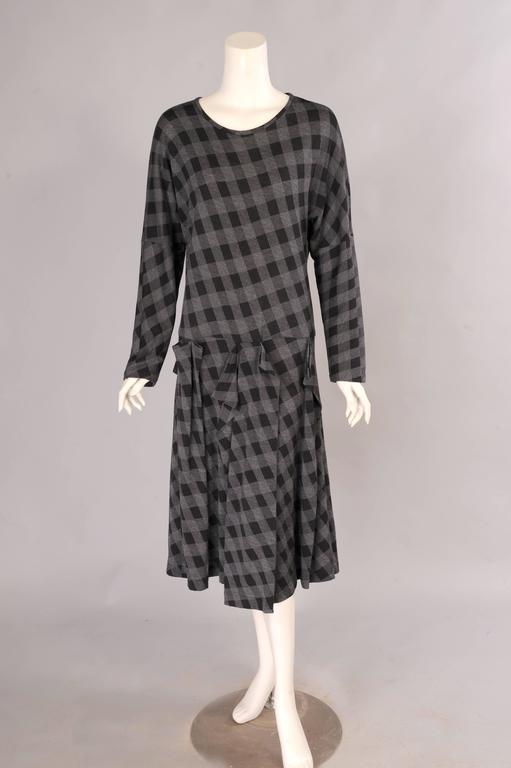 A round neckline, long sleeves and a dropped waist add to the easy comfort of this dress from Comme des Garcons. The skirt has an interesting and varied pleated detail at the dropped waist. The dress slips on over your head and it is in excellent