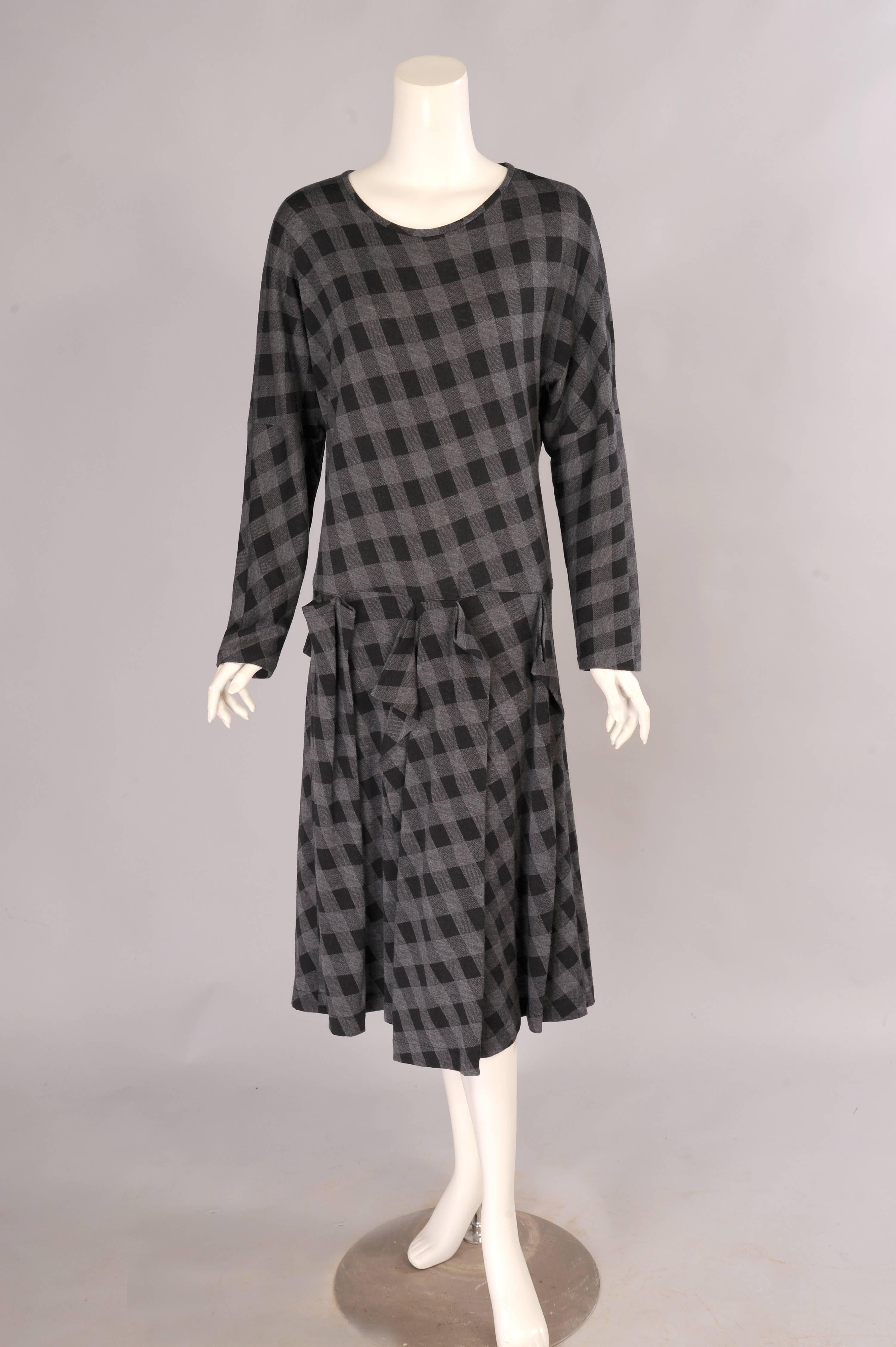 A round neckline, long sleeves and a dropped waist add to the easy comfort of this dress from Comme des Garcons. The skirt has an interesting and varied pleated detail at the dropped waist. The dress slips on over your head and it is in excellent