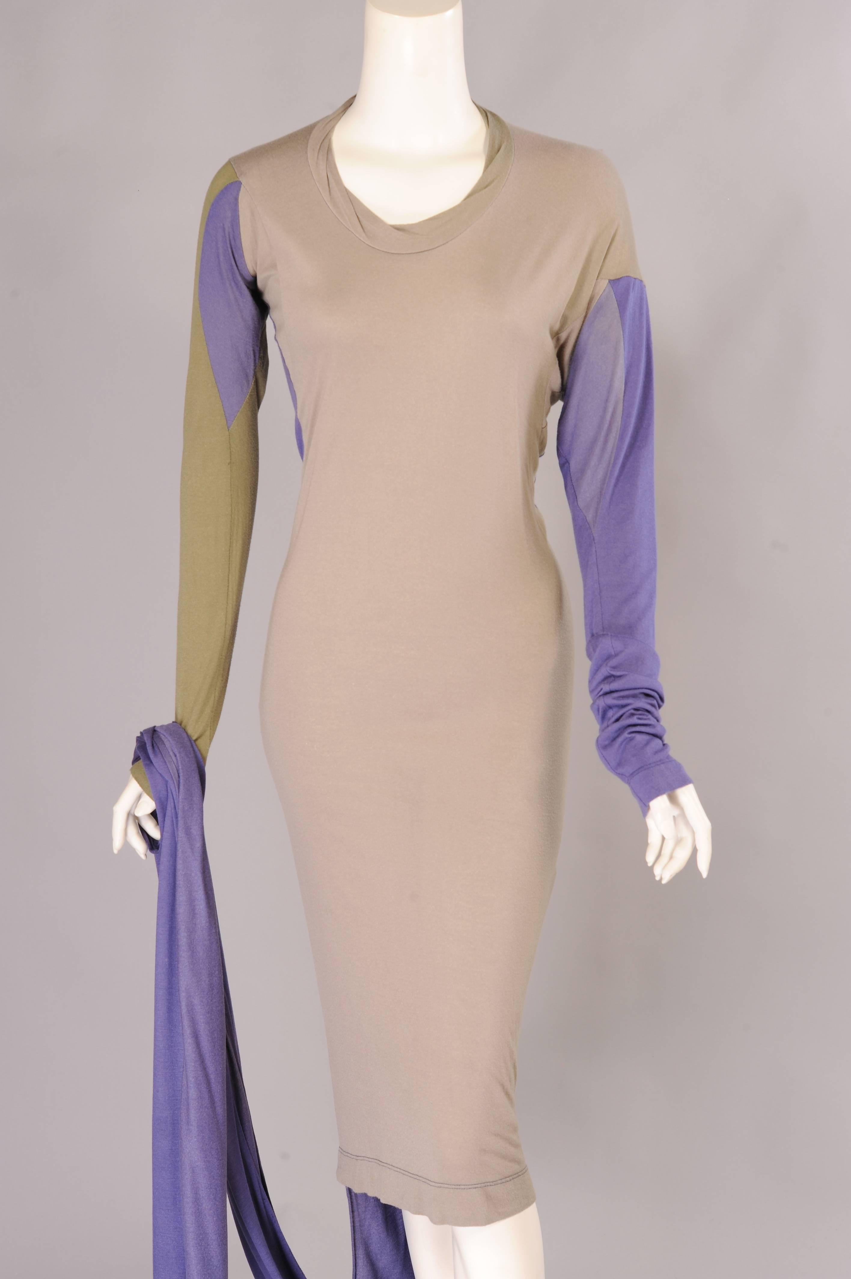 Grey-beige, lavender and khaki green combine in this Tee shirt dress from Vivienne Westwood. The dress has a round neckline, long sleeves and a purposefully mismatched shoulder line. The front of the dress is knee length. The back of the dress is