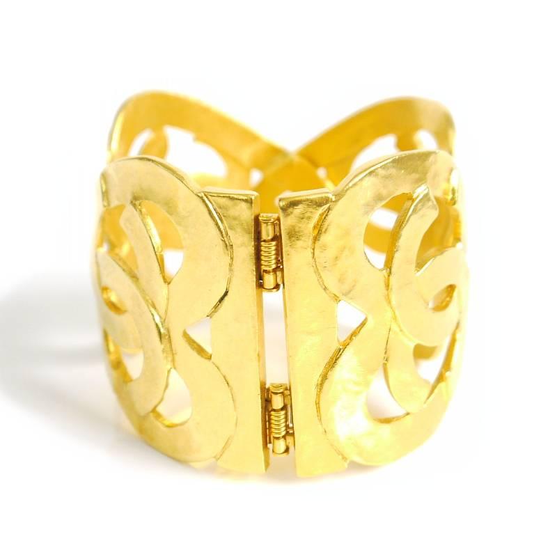 Vintage Chanel heart motif gold bangle. Wide size cuff bracelet. The CC signature is formed into a feminine, large heart shape. This vintage Chanel, wide cuff bracelet is the perfect accessory for every woman’s wardrobe. Collectible vintage from