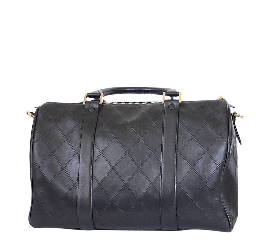 Vintage Chanel Black Lambskin Duffel Bag. You can wear the bag in hand held or over your shoulder with detachable shoulder strap. Easy to carry, perfect size for daily use. Spacy interior holds your daily essentials, i pad and everything you