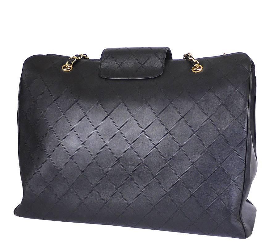 CHANEL black lamb skin flat quilt weekender, weekender shoulder bag in excellent used condition. This overnight bag offers a spacious interior and a large CC turn lock closure. It is ideal as a shopping bag or weekend bag. Many celebrities are