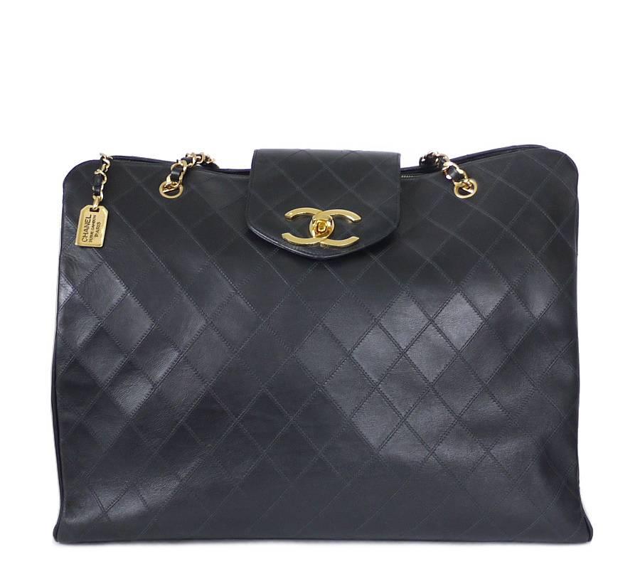 CHANEL black lamb skin flat quilt overnight bag, weekender shoulder bag in excellent used condition. This overnight bag offers a spacious interior and a large CC turn lock closure. It is ideal as a shopping bag or weekend bag. Many celebrities are