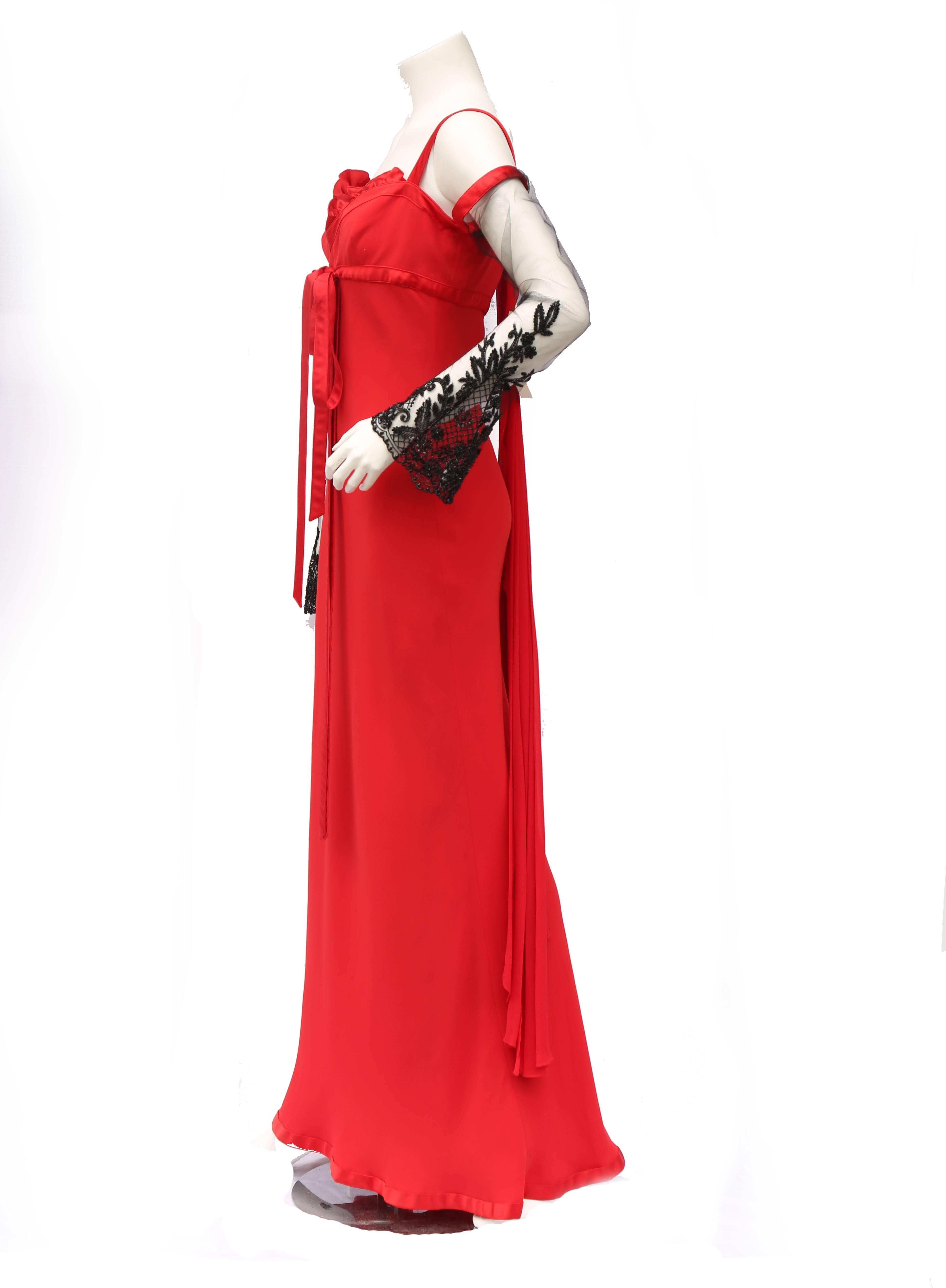 A classic red Valentino gown with bow detail on the front and a chiffon drape detail on the back complete with dramatic lace net sleeve embellished with beads and sequins

Measurements taken flat in inches
Bust – 14 
Waist – 15
Hips -20
Length