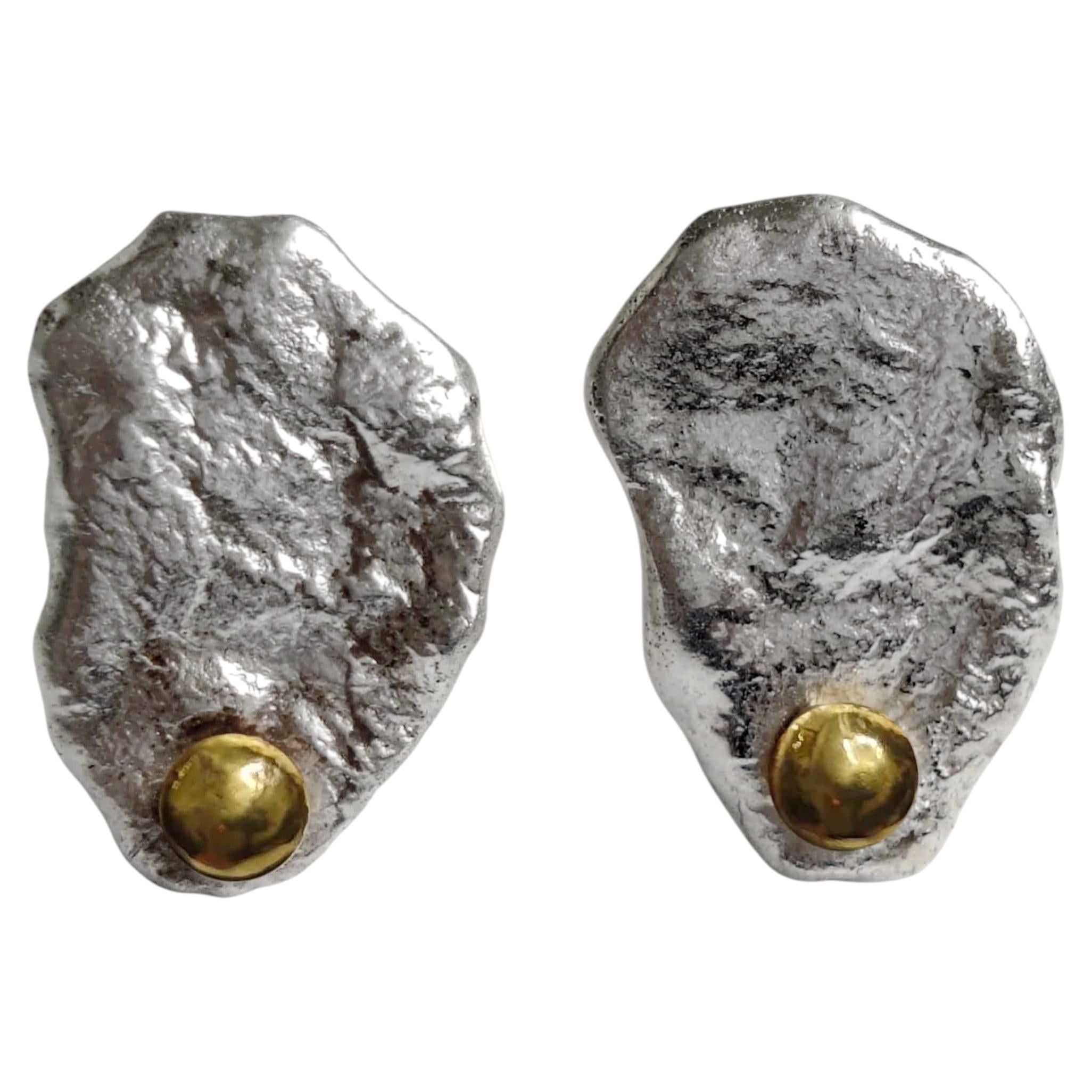 Auffällige Silber- und Goldohrringe in organischer Form für einen markanten Look