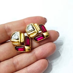 Pendientes de pasarela de Guy Laroche, con diseño geométrico en tono dorado y piedras rojas y transparentes